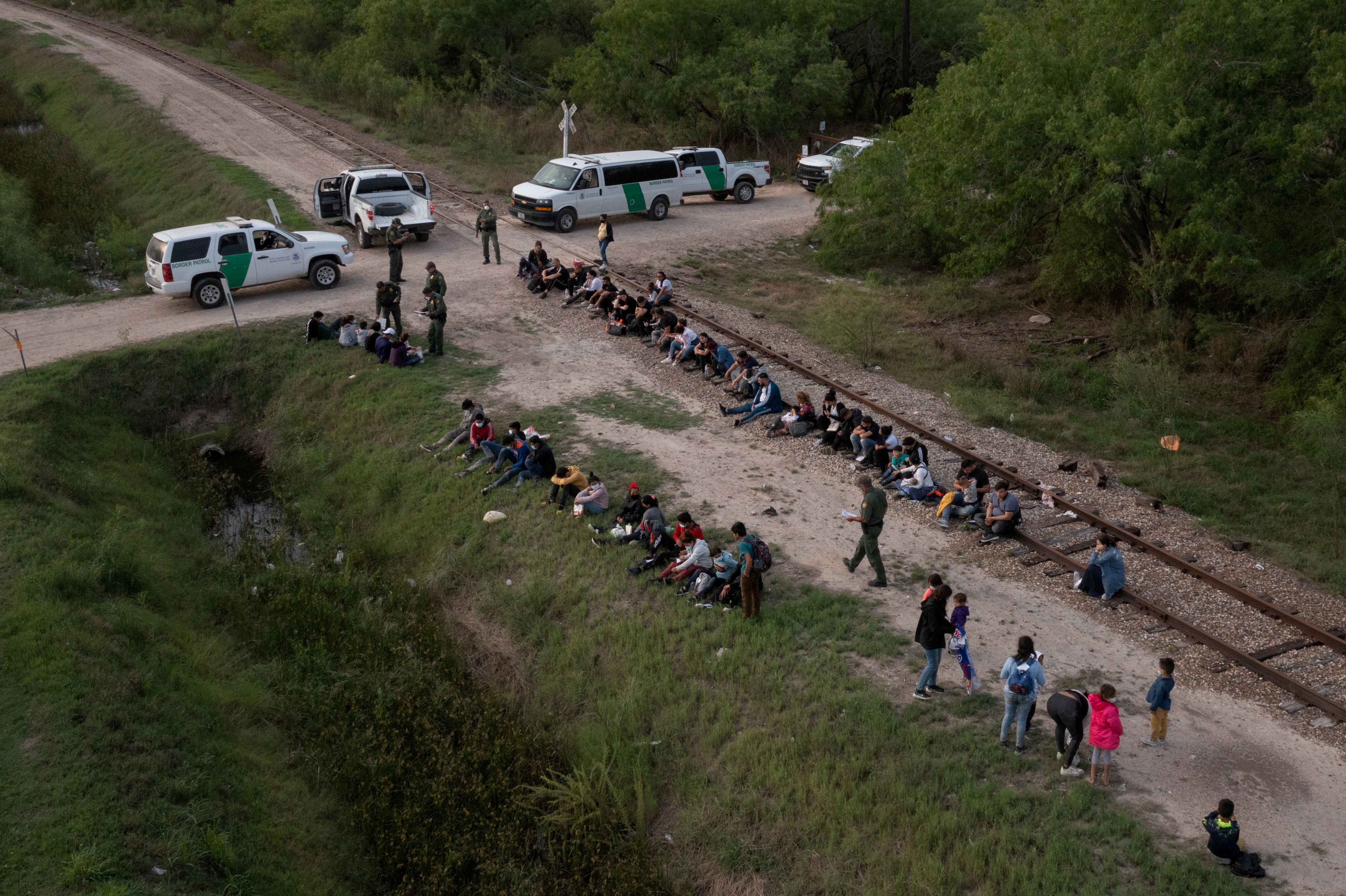 Dozens of asylum-seeking migrants from Romania, Armenia, and Central America, including a group of unaccompanied minors, await to be transported to a U.S. border patrol processing facility after crossing the Rio Grande river into the United States from Mexico on a raft in La Joya, Texas on May 5, 2021. Picture taken with a drone.REUTERS
