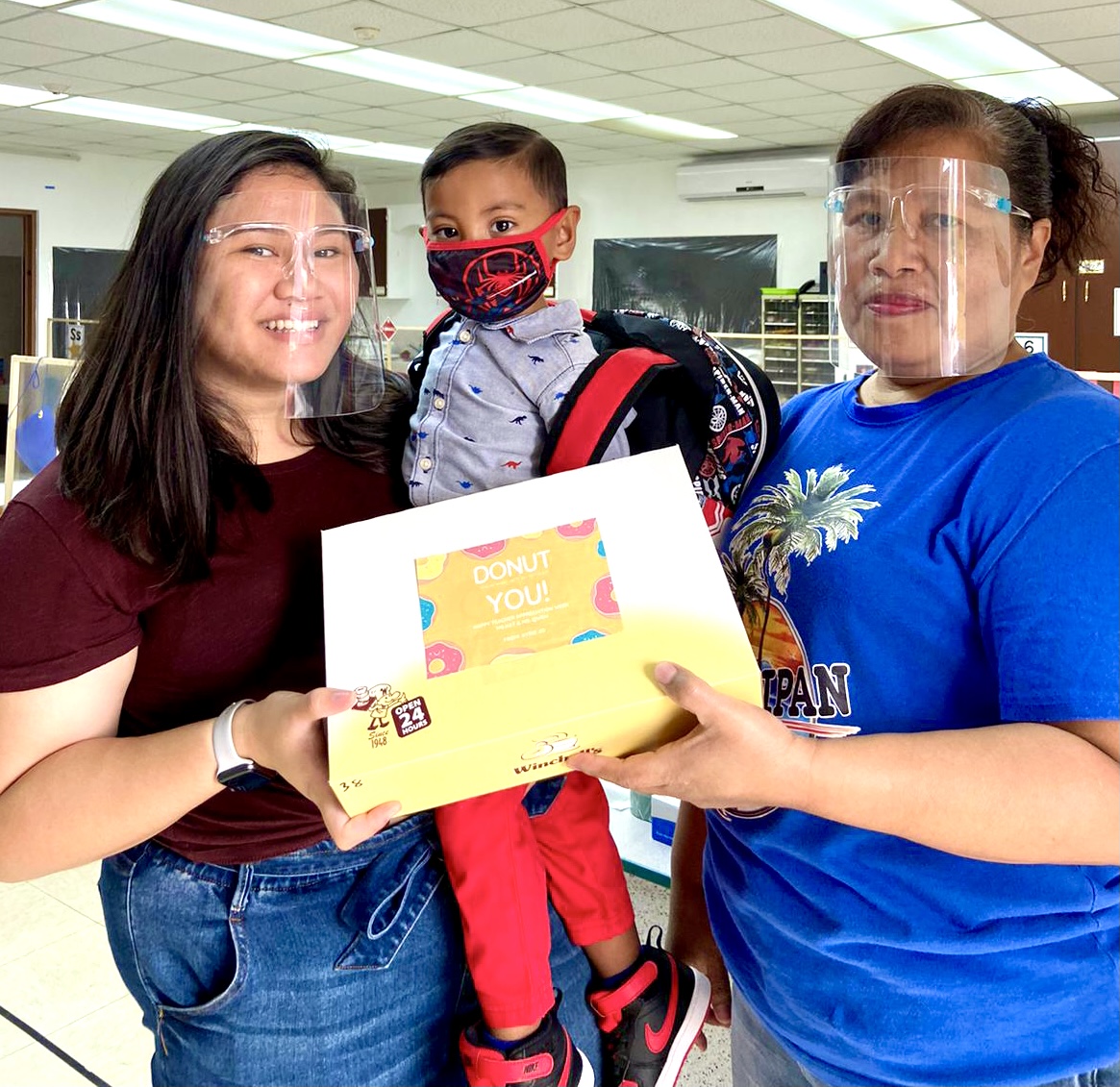 Kathleen Laurio and Quendoyne Brosbesong of Early Head Start/Head Start Chalan Kanoa receive a gift from Kyrie Aldan Tenorio, a grandson of former Board of Education Chairwoman Janice Marie A. Tenorio, who is IT&E CNMI’s customer service and government relations manager.
