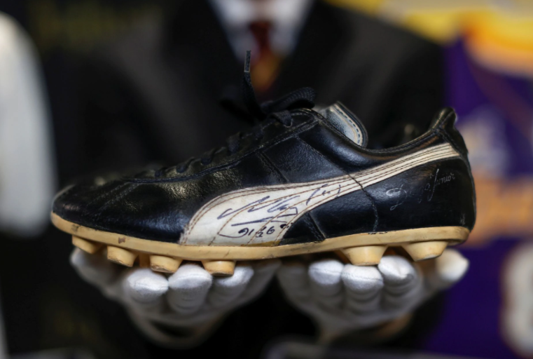 Kendall Capps, sports director at Julien's Auctions, holds a pair of soccer boots worn and autographed by late soccer star Diego Armando Maradona ahead of the upcoming "Sports: Legends" auction in Culver City, California on May 3, 2021.REUTERS