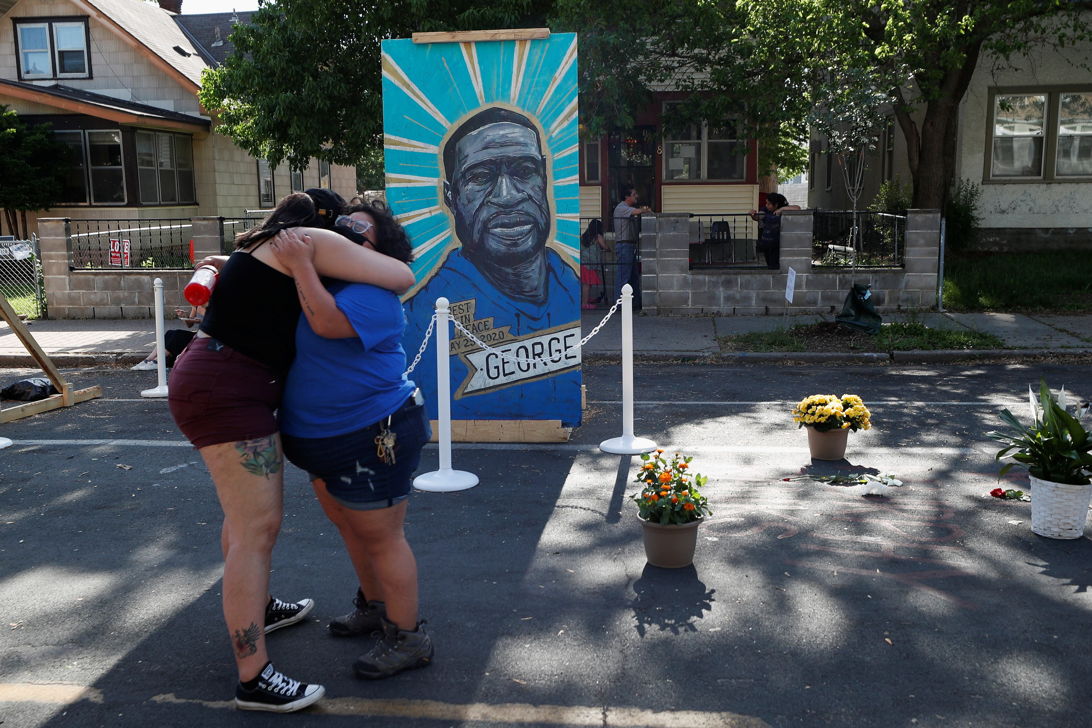 People embrace as they attend a Celebration of Life festival in honor of George Floyd, who was killed by Minneapolis police one year ago, at George Floyd Square in south Minneapolis, Minnesota, May 25, 2021.REUTERS