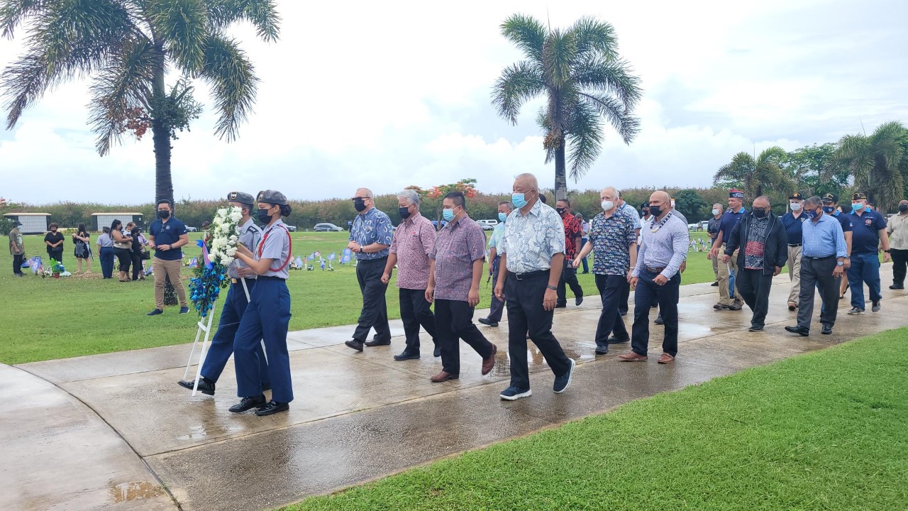 Distinguished guests walk toward the flags at the CNMI Veterans Cemetery to lay the Memorial Day wreath.
