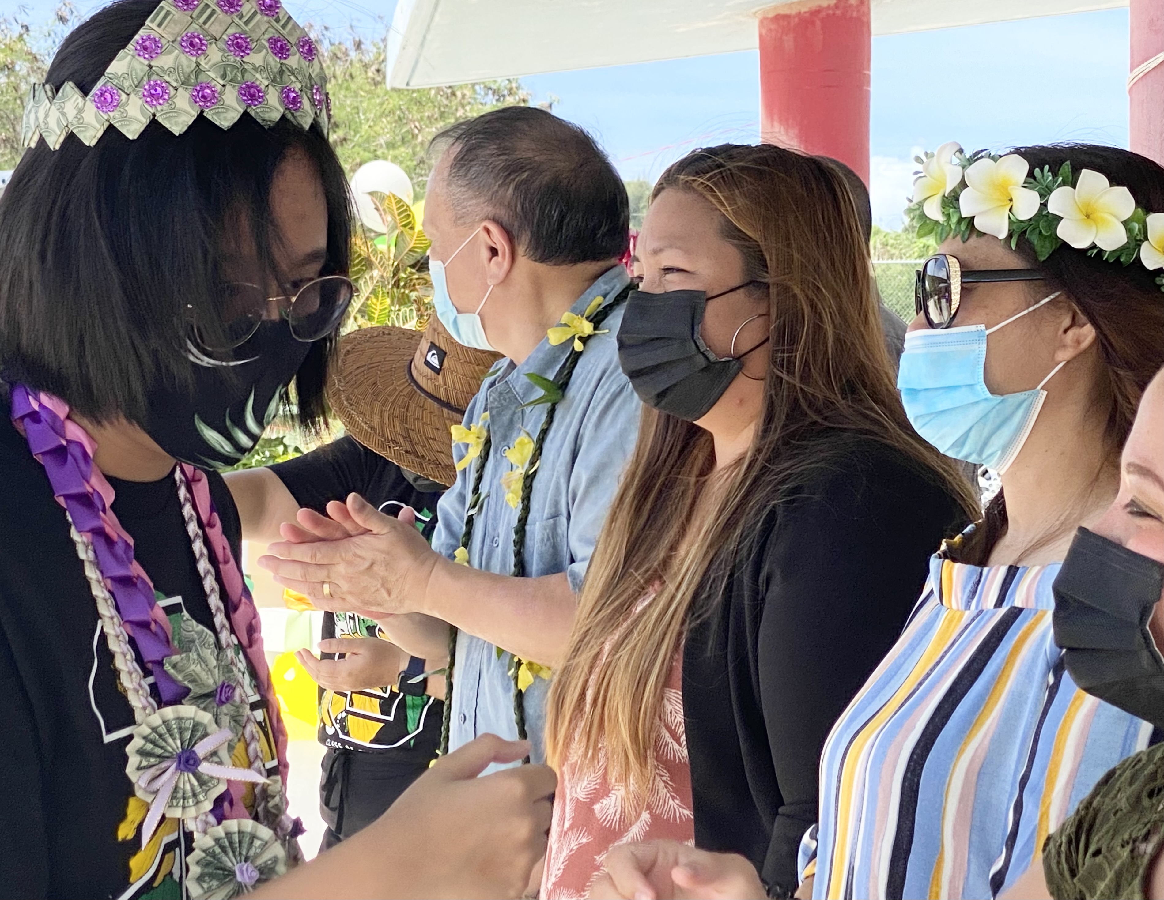 A promoted student fist bumps school district officials.