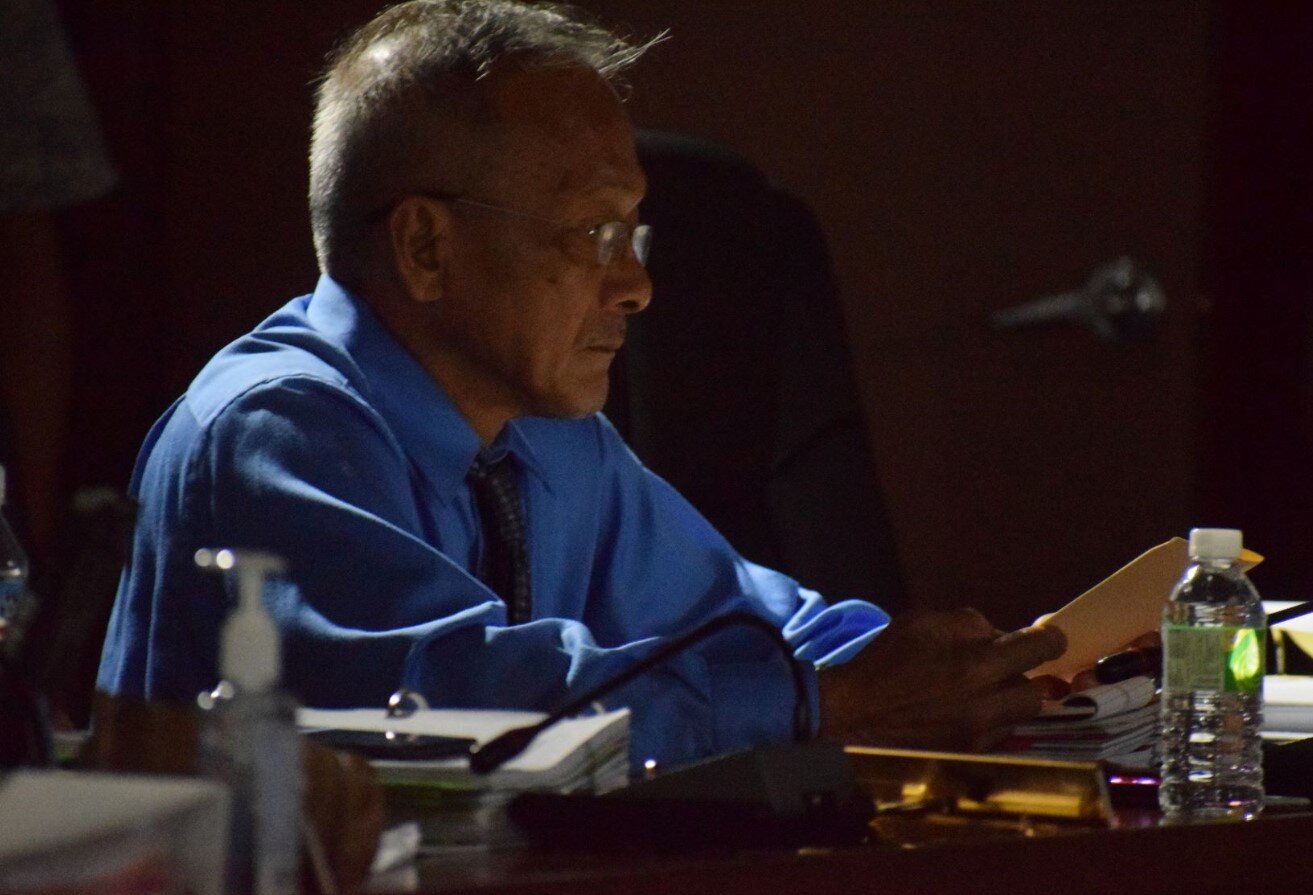 With the emergency light on, Rep. Vicente Camacho reviews a piece of legislation after power went out during a House session on Wednesday.