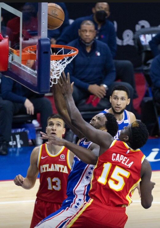 Philadelphia 76ers center Joel Embiid (21) scores past Atlanta Hawks center Clint Capela (15) during the first quarter in game five of the second round of the 2021 NBA Playoffs at Wells Fargo Center in Philadelphia, Pennsylvania on June 16, 2021.