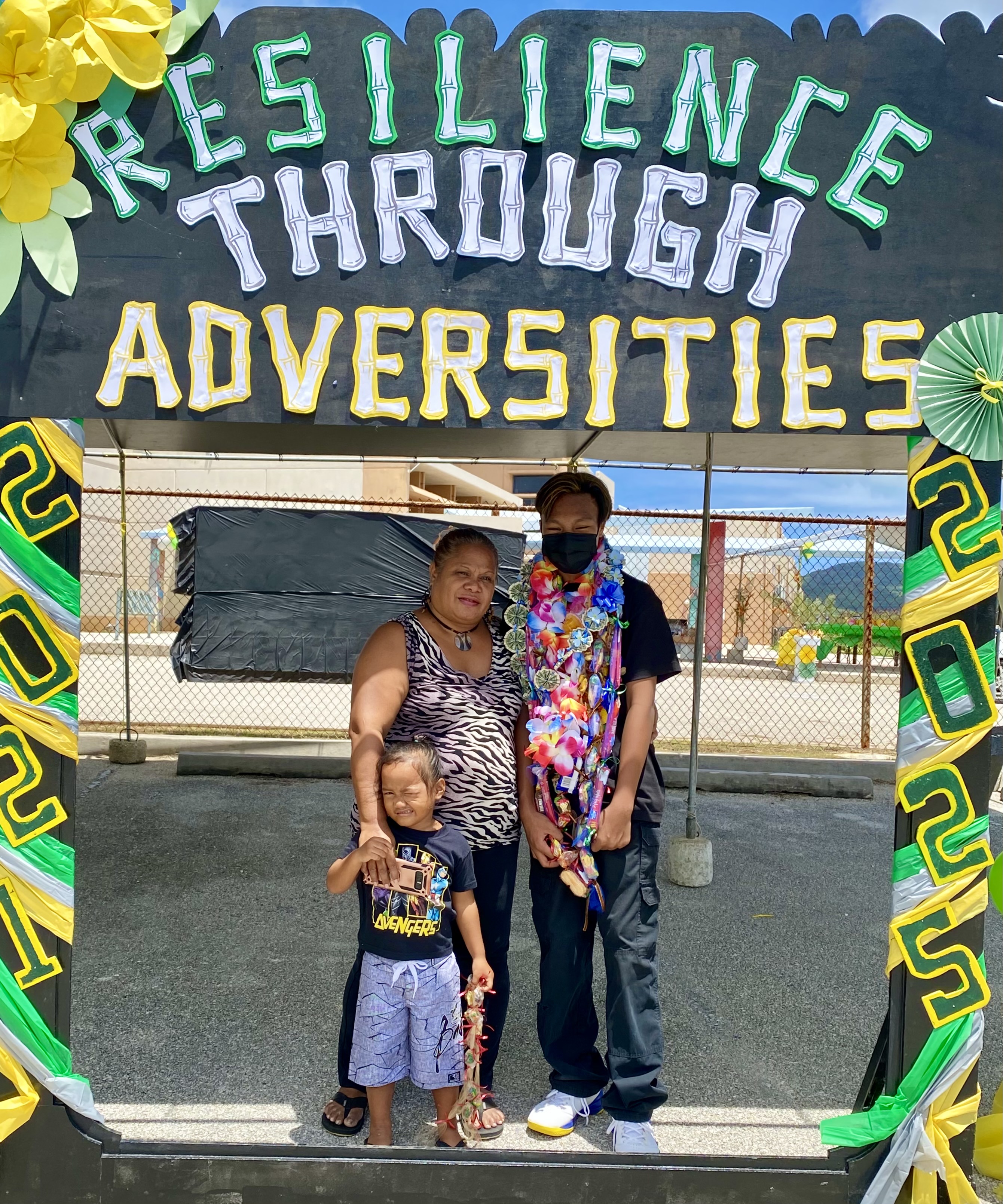 A promoted eighth grade student poses for a photo with his family.