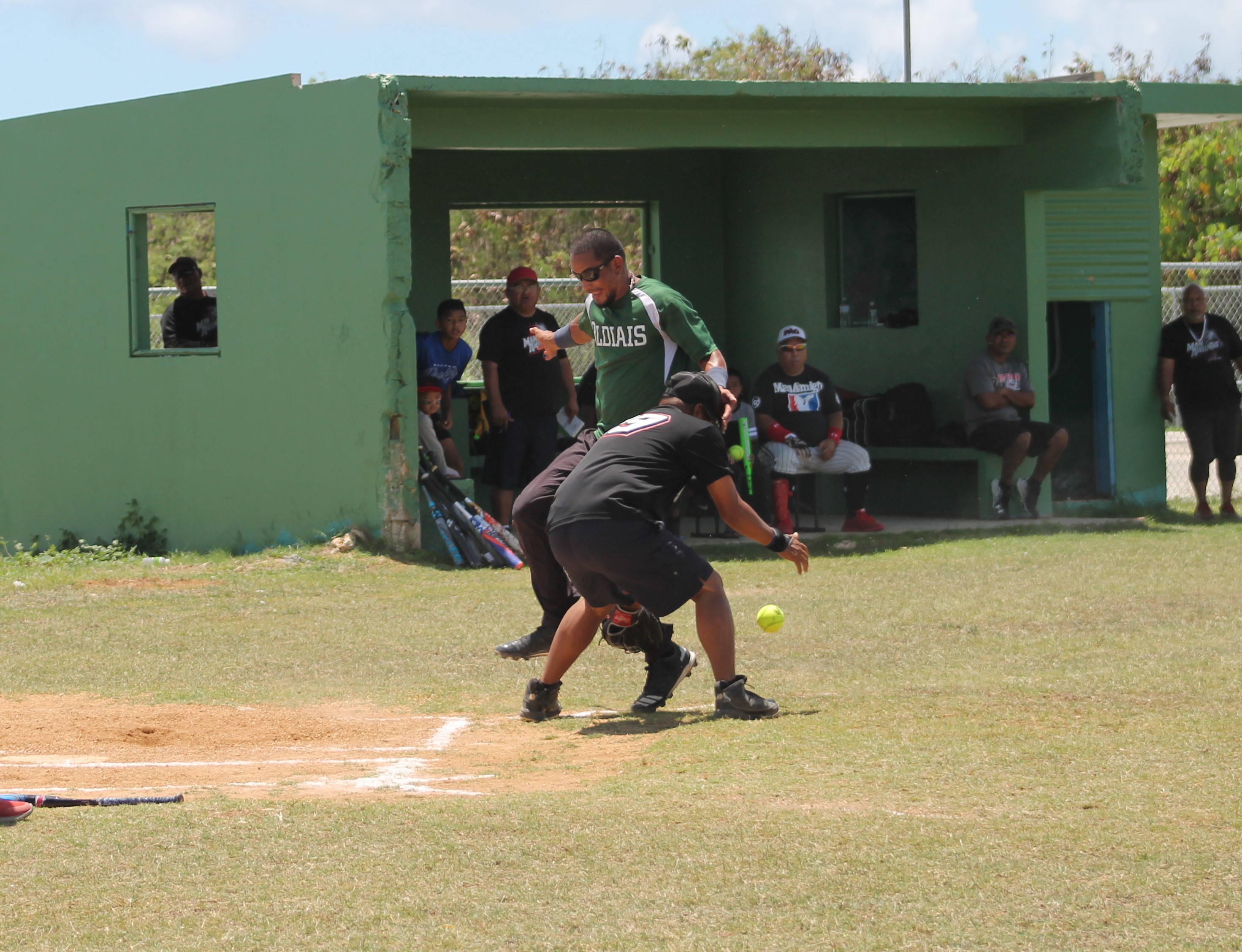 PeLeLiu's Cartfield Sablan races home as Man Amigos' catcher Mario Aguon attempts to tag him out.