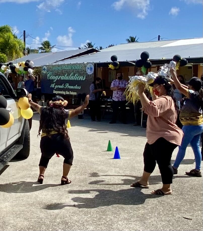 A promoted student dances with joy.