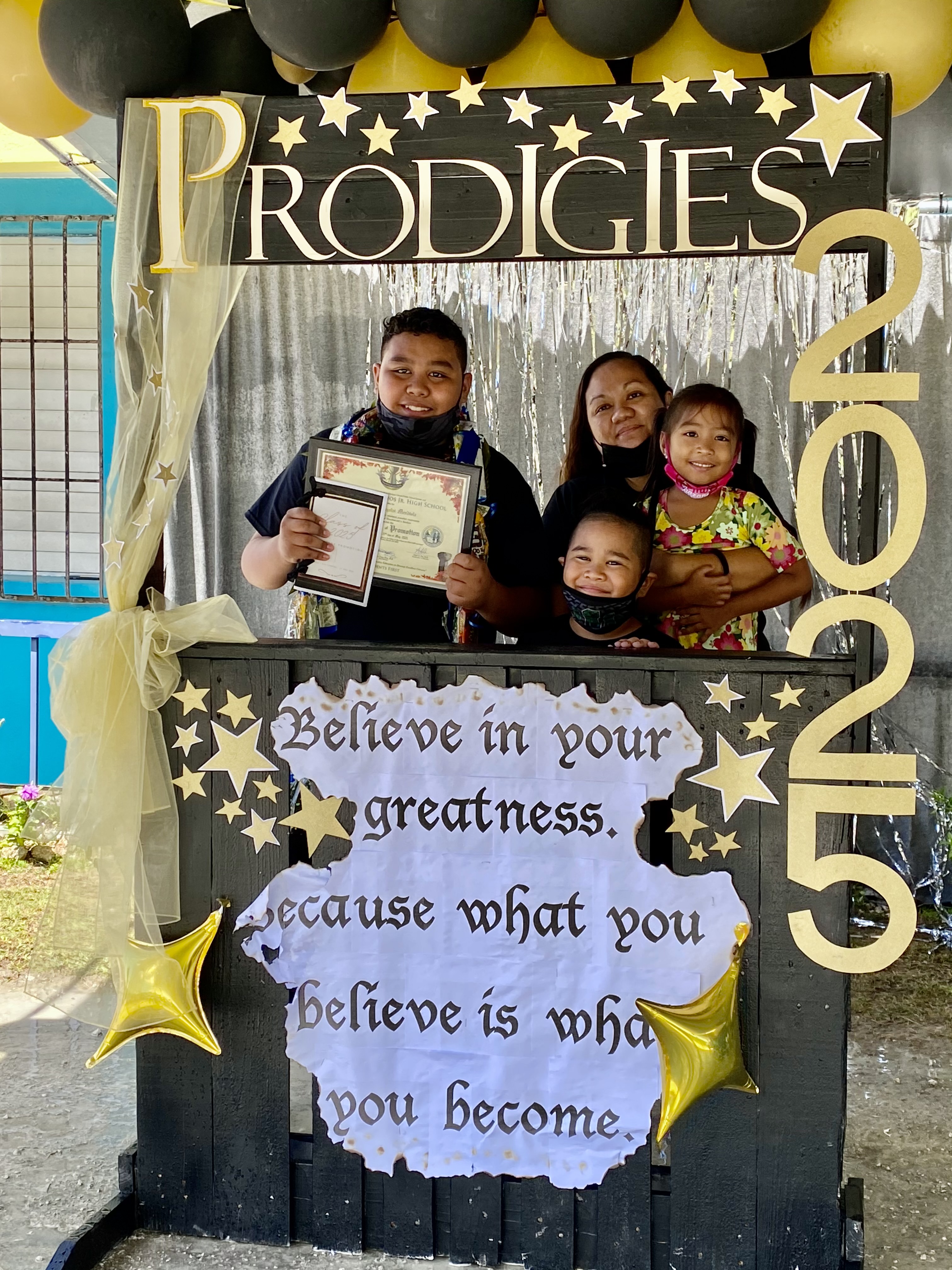 A promoted student with his family members at the photo booth.