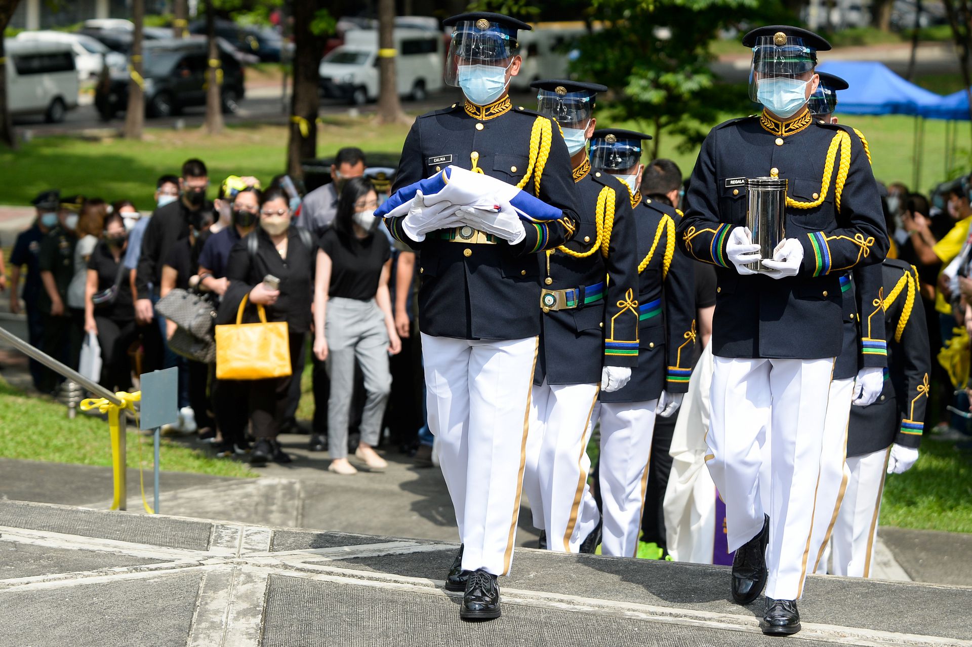 A military honor guard carries the urn of former Philippine President Benigno Aquino prior to the public viewing, at the Church of Gesu in Ateneo de Manila University, Quezon City, Metro Manila, June 25, 2021.