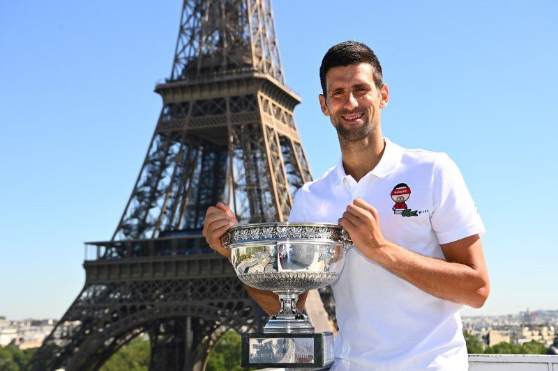 Serbia's Novak Djokovic poses with the trophy in front of the Eiffel Tower in Paris on June 14, 2021 after winning the men's singles French Open title.