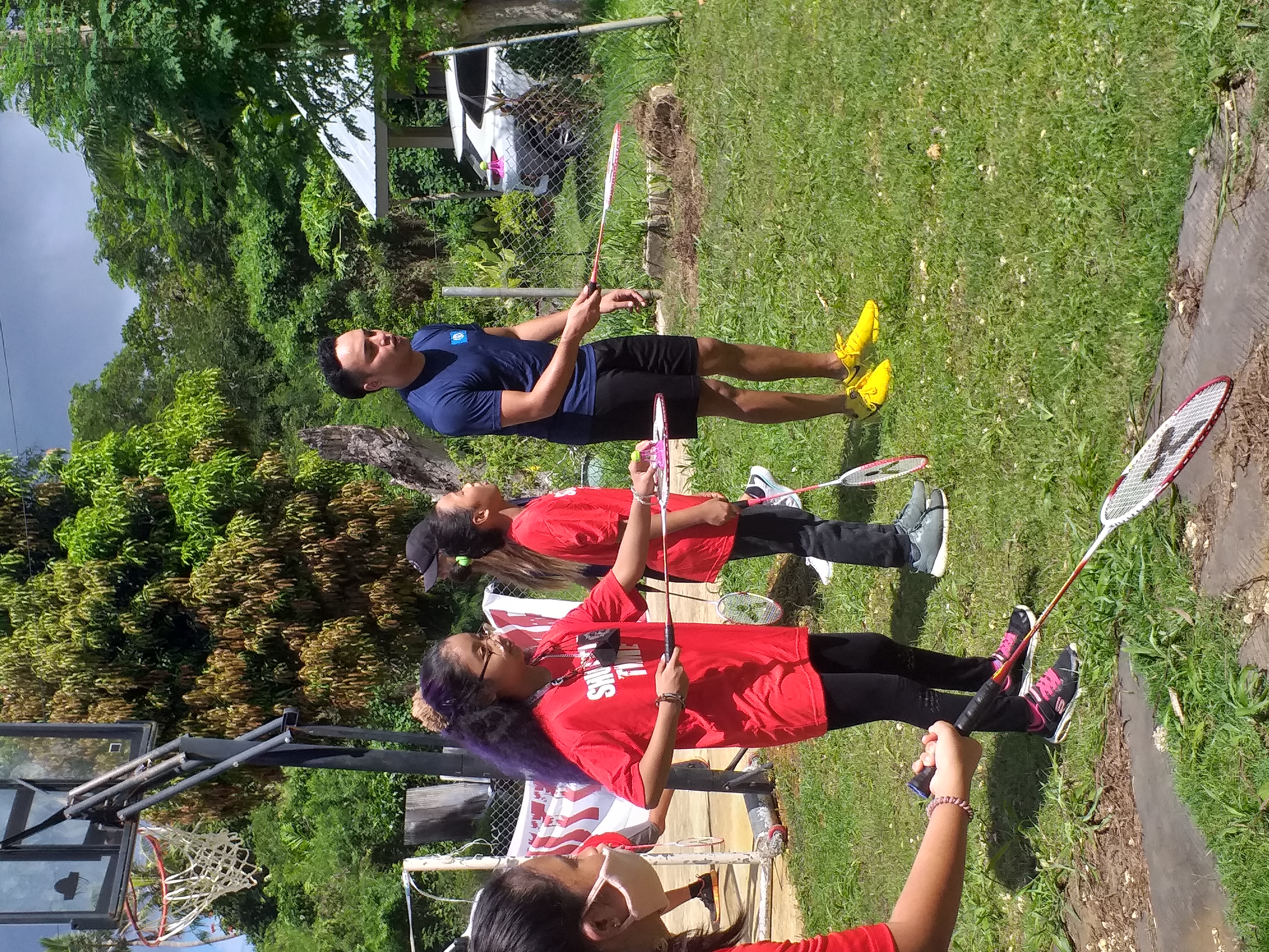 Northern Marianas Badminton Association vice president Nate Guerrero, right, demonstrates to Green Meadow School students the “bouncing bird” drill during a Shuttle Time session at the Falcons’ grounds on Tuesday.