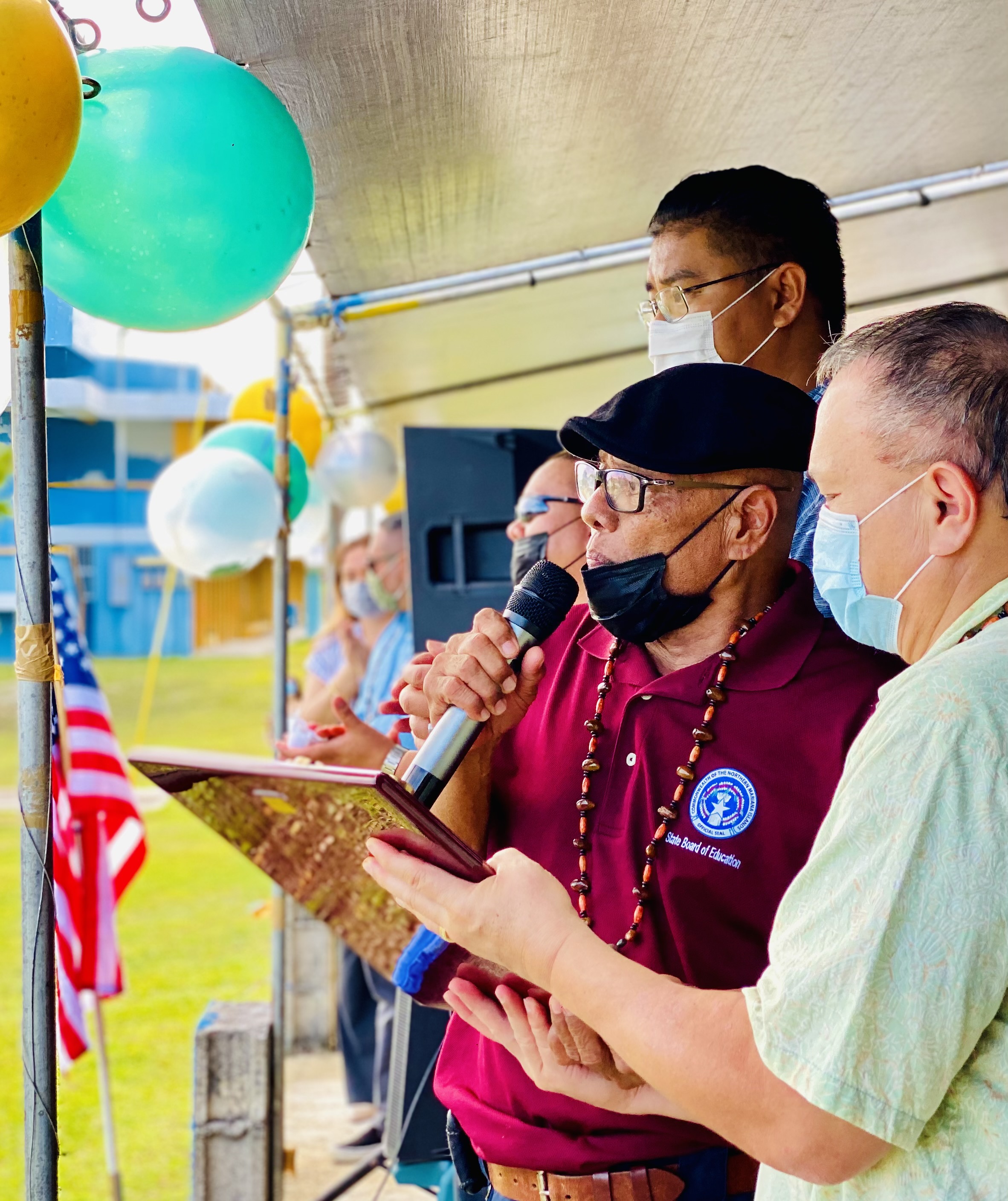 BOE Vice Chairman Herman Atalig is assisted by Chairman Andrew Orsini and BOE member Antonio Borja in the presentation of an academic achievement award.