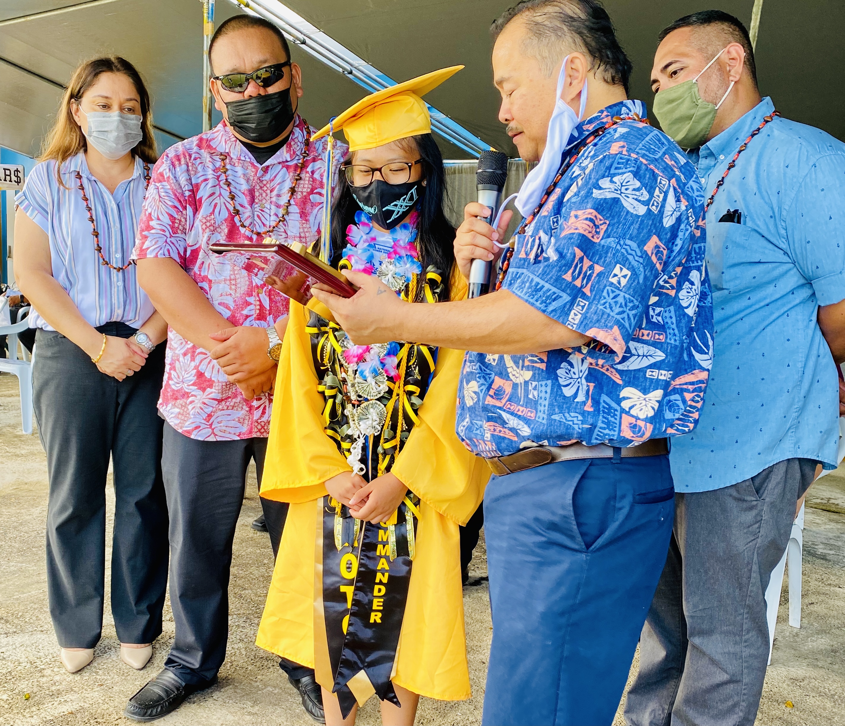 Commissioner Education Dr. Alfred B. Ada presents the Commissioner of Education Award to class salutatorian Elkana Rodriguez Depalog. Also in photo are Associate Commissioner Eric Magofna, Public School System Special Education Director Donna Flores and science program coordinator Asapmar Ogumoro.