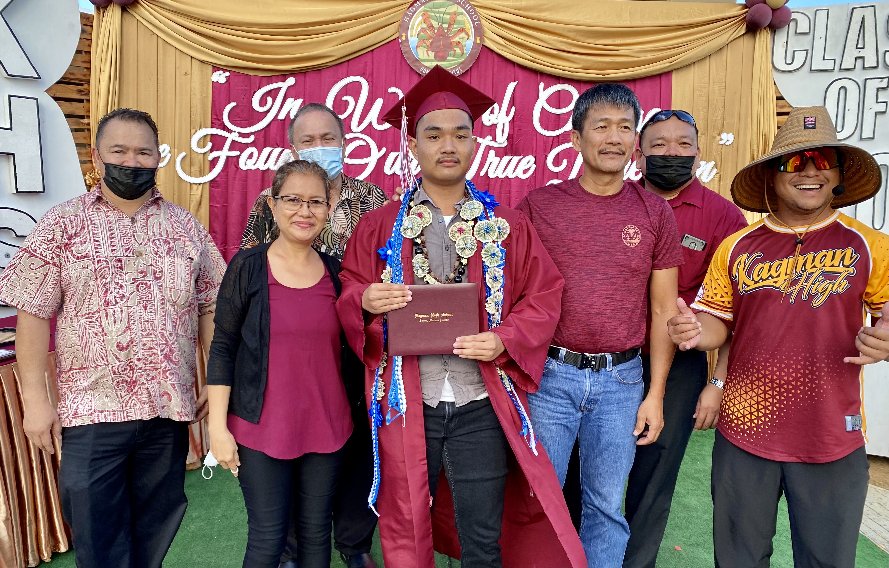 Patrick Arceo holds his diploma as he poses for a photo with his proud parents, Commissioner of Education Dr. Alfred B. Ada, Board of Education Chairman Andrew L. Orsini, Associate Commissioner for Administration Eric Magofna and Kagman High School principal Ben Jones.