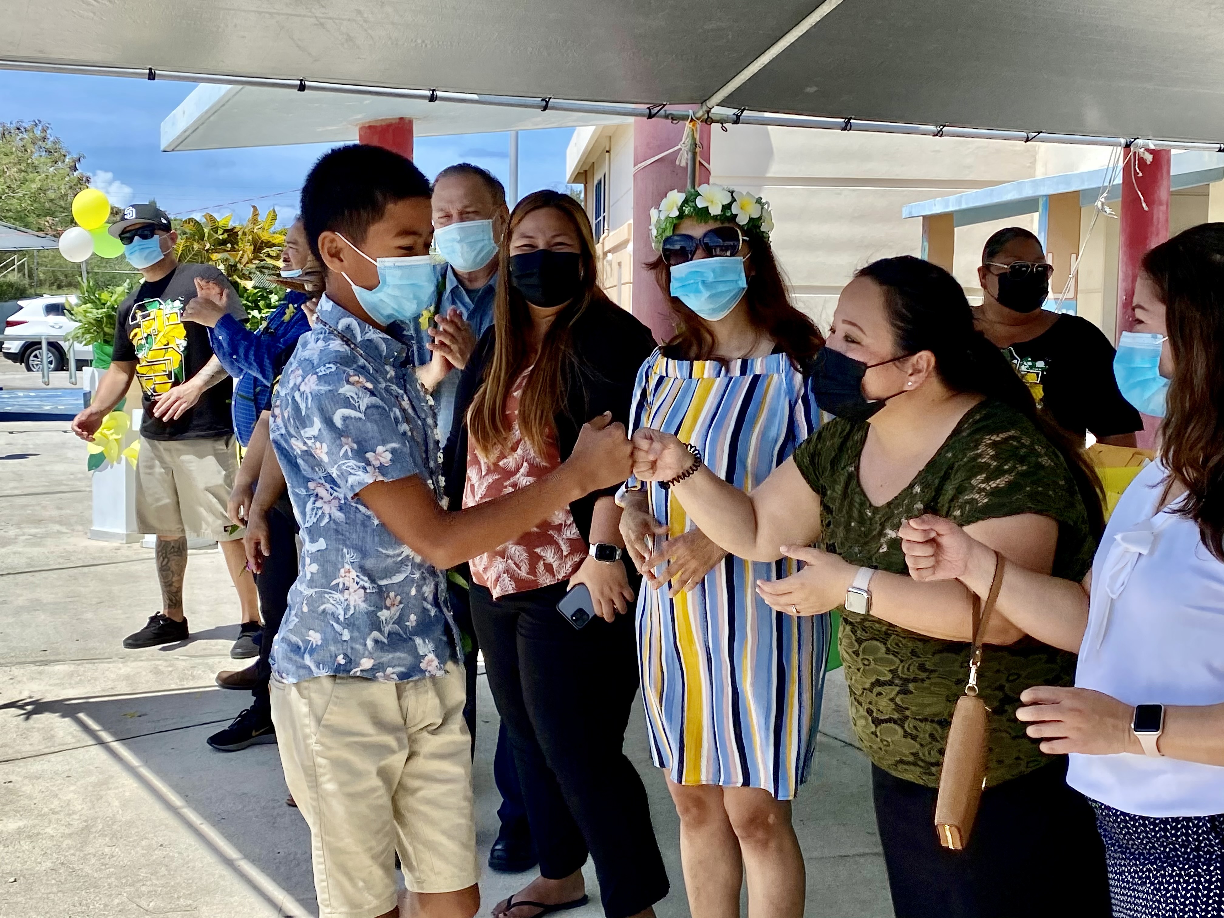 Newly promoted eighth grader Kideichi Alafanso Blanco is congratulated by Public School System Human Resources Officer Director Lucretia Deleon-Guerrero and Finance and Budget Director Arlene Lizama as Board of Education Chairman Andrew Orsini and Head Start/Early Head Start Director Lathania Angui look on.