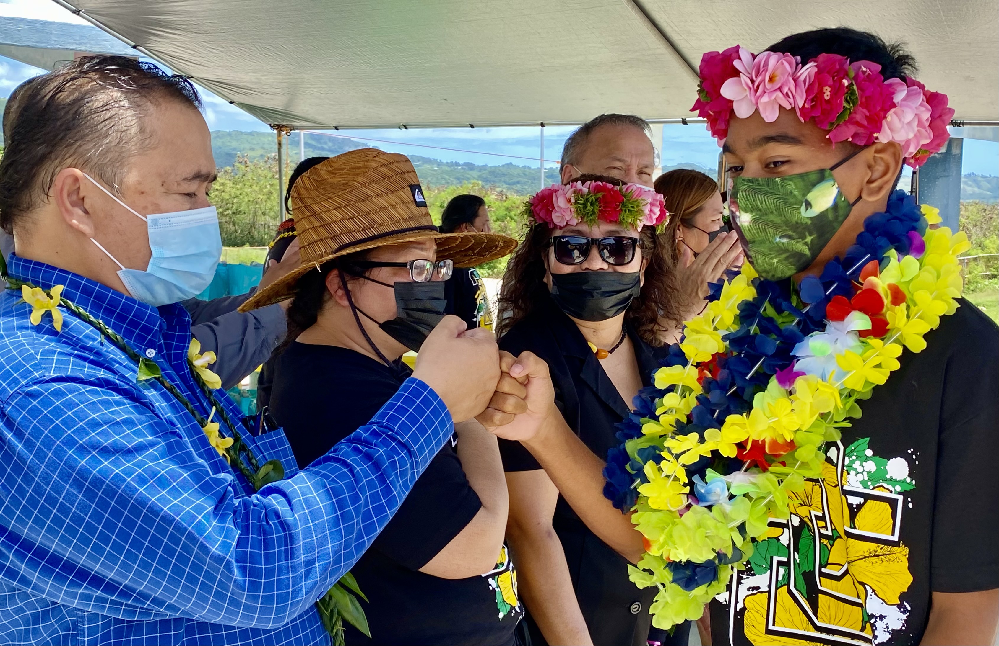 Education Commissioner Dr. Alfred Ada fist bumps a promoted eighth grader.