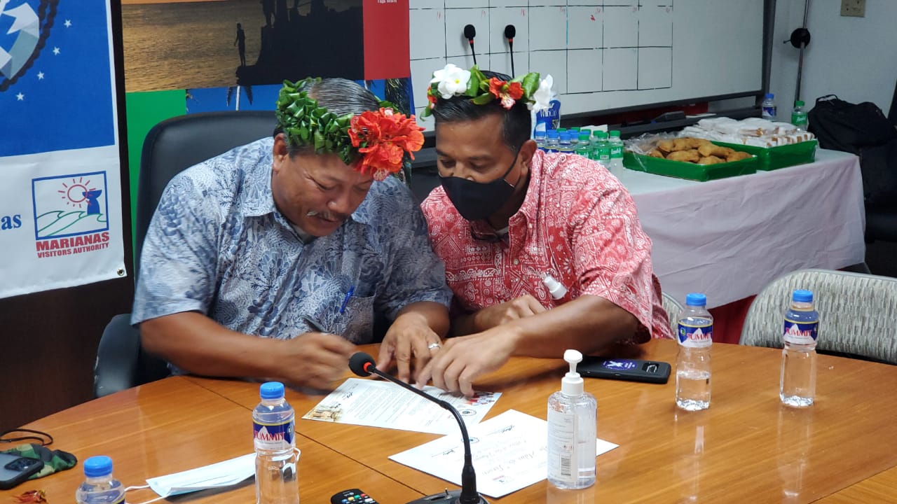 Mayor of Tinian and Aguigan Edwin P. Aldan, left, signs the Hafa Adai & Tirow Pledge on June 11, 2021, as Senate President Jude Hofschneider looks on at Tinian Mayor’s Office.  Aldan signed the pledge along with 14 other elected and business leaders from the island.