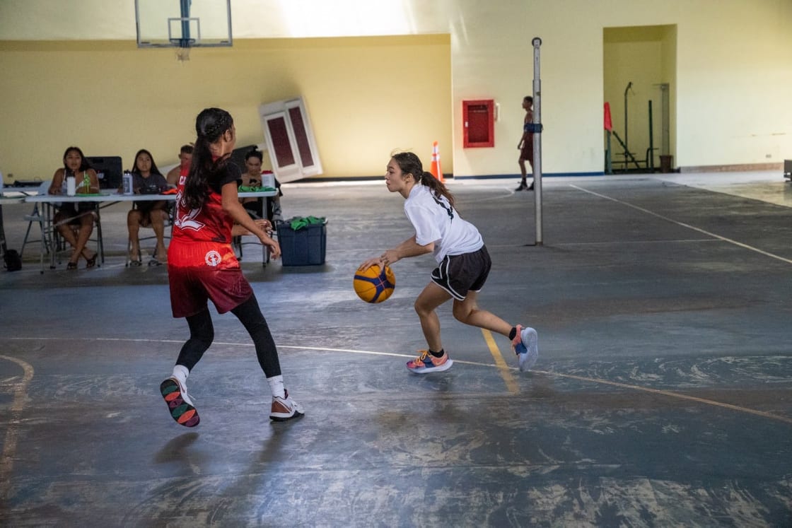Kaia Travilla dribbles away from a defender during a Summer Heat 3v3 Basketball Tournament game Saturday at the Tinian Gymnasium.