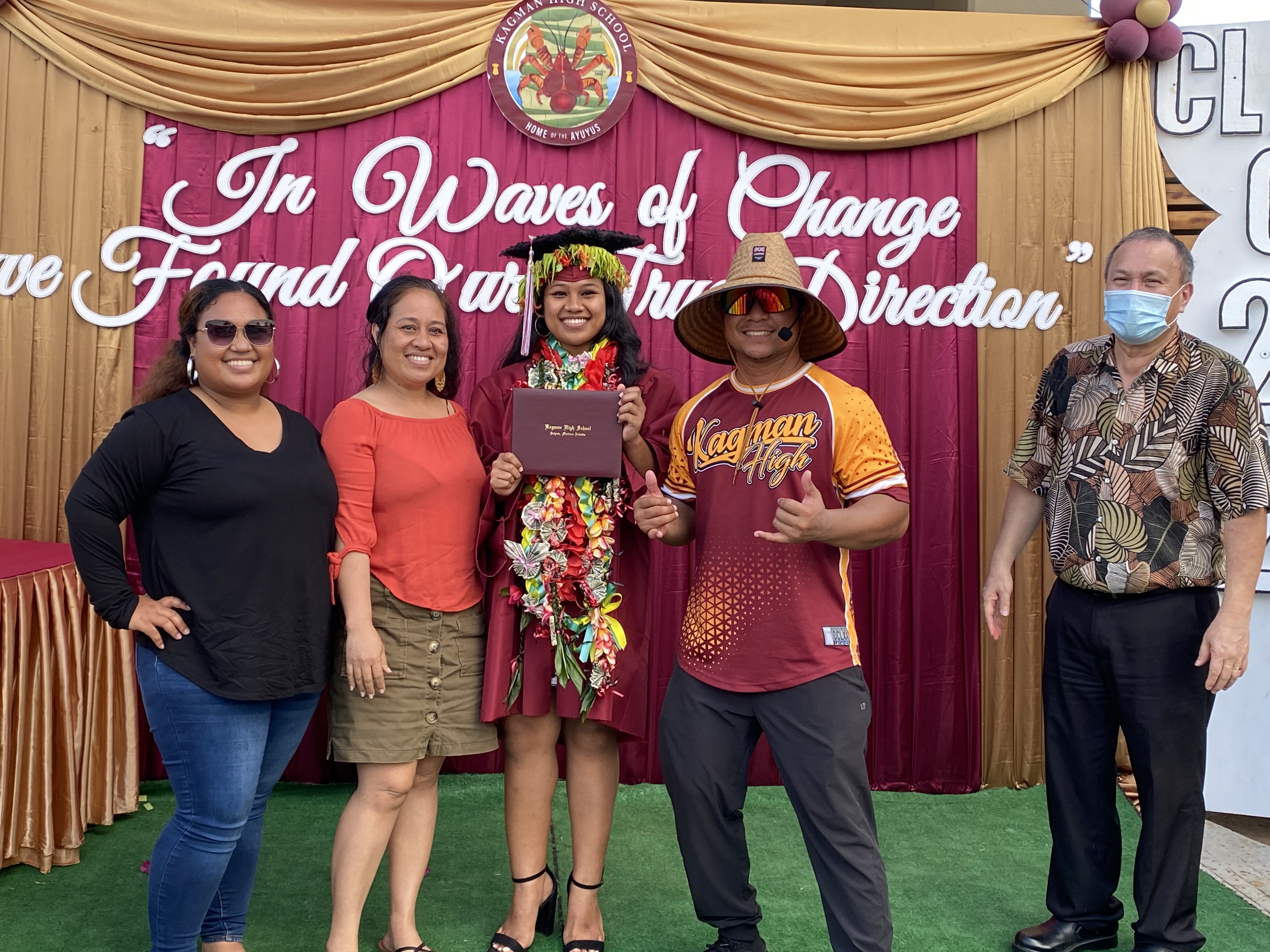 A proud graduate with her family and education officials.