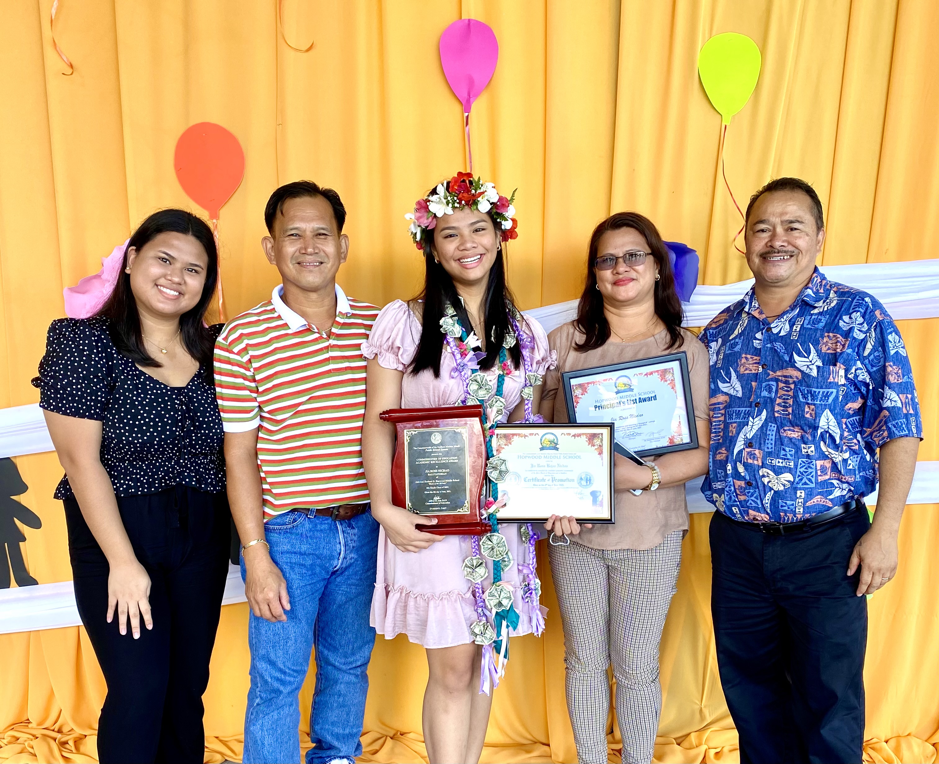 Class salutatorian and recipient of the Commissioner of Education Academic Achievement Award Jia Ross B. Nicdao, center, with her family and Commissioner of Education Dr. Alfred B. Ada, right.