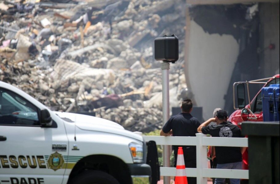 Rescue workers look at the debris of a partially collapsed residential building as the emergency crews continue search and rescue operations for survivors, in Surfside, near Miami Beach, Florida,  June 26, 2021. 