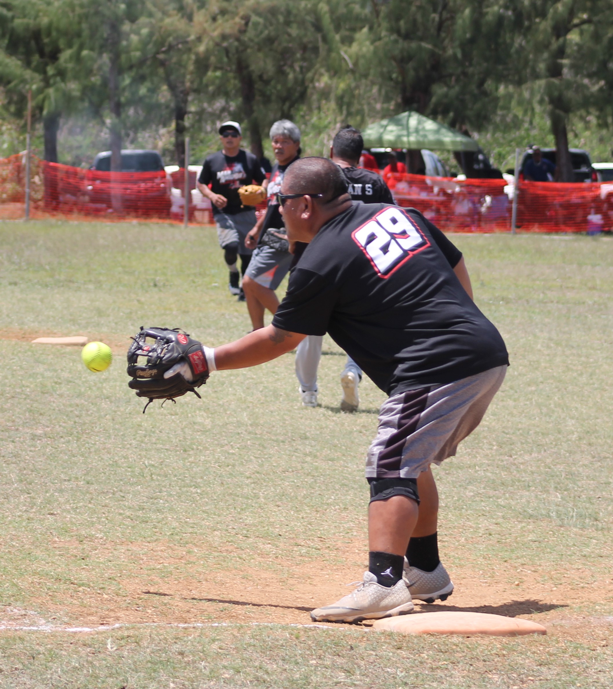 Man Amigos' first baseman Jun Lizama extends for the catch and the out.