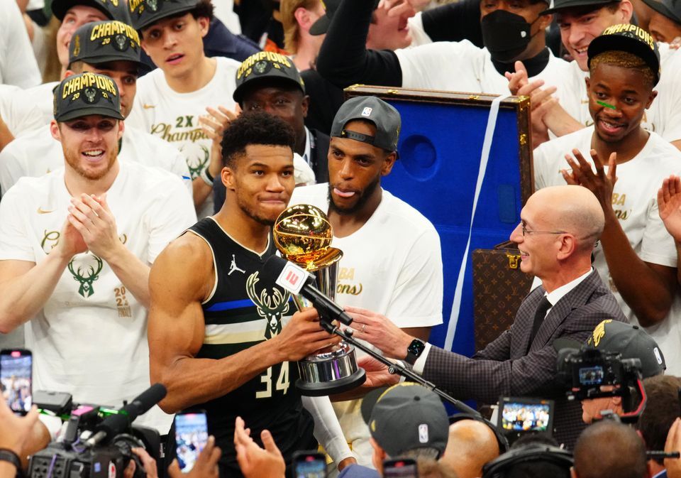 Milwaukee Bucks forward Giannis Antetokounmpo (34) accepts the Bill Russell NBA Finals Most Valuable Player Award from NBA commissioner Adam Silver after game six of the 2021 NBA Finals against the Phoenix Suns at Fiserv Forum in Milwaukee, Wisconsin on July 20, 2021.