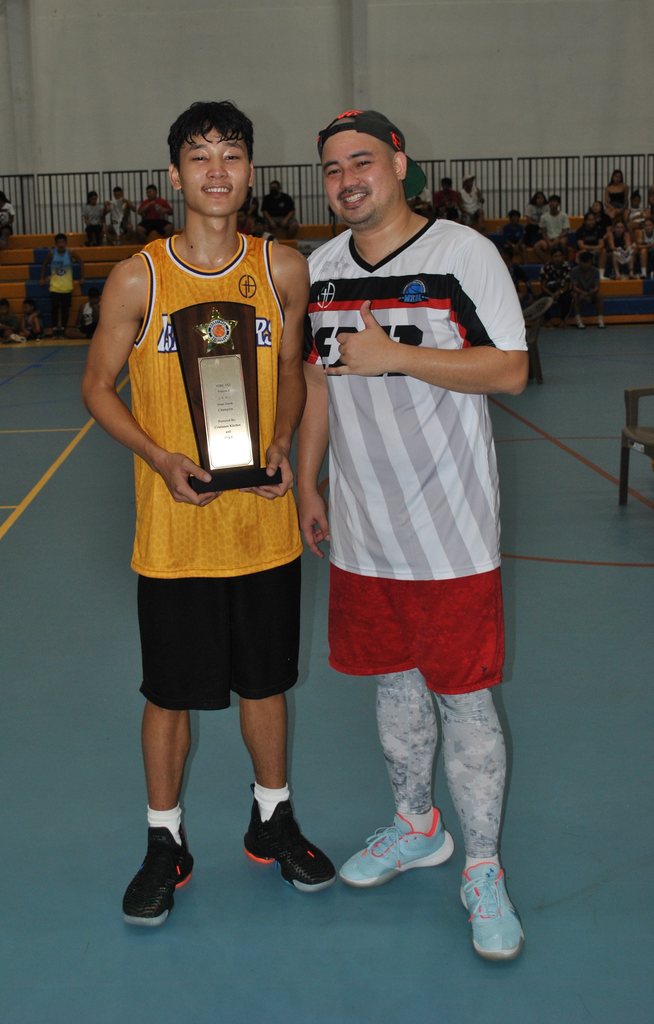 Coby Santos poses with the Slam Dunk Trophy and  Clint Albert of the Marianas International Basketball League.