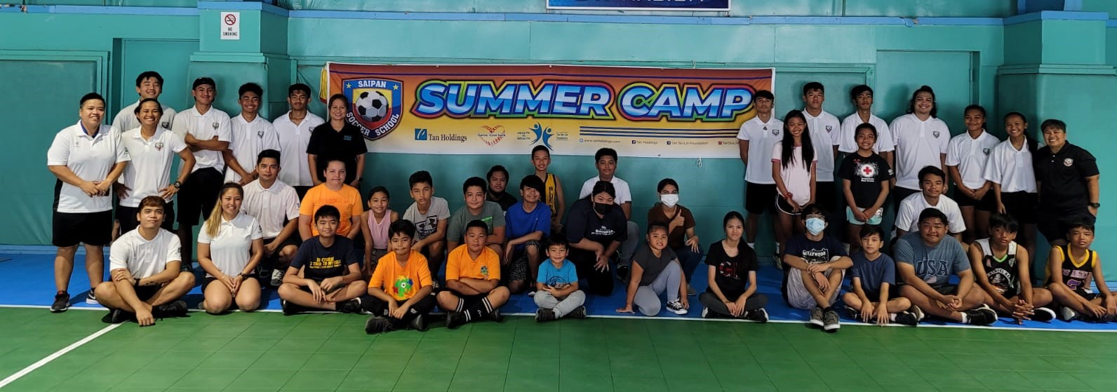 Participants in the Summer Sports Camp 2021 pose with volunteers and Tan Siu Lin Foundation and Saipan Soccer School officials for a group photo before starting their sessions.