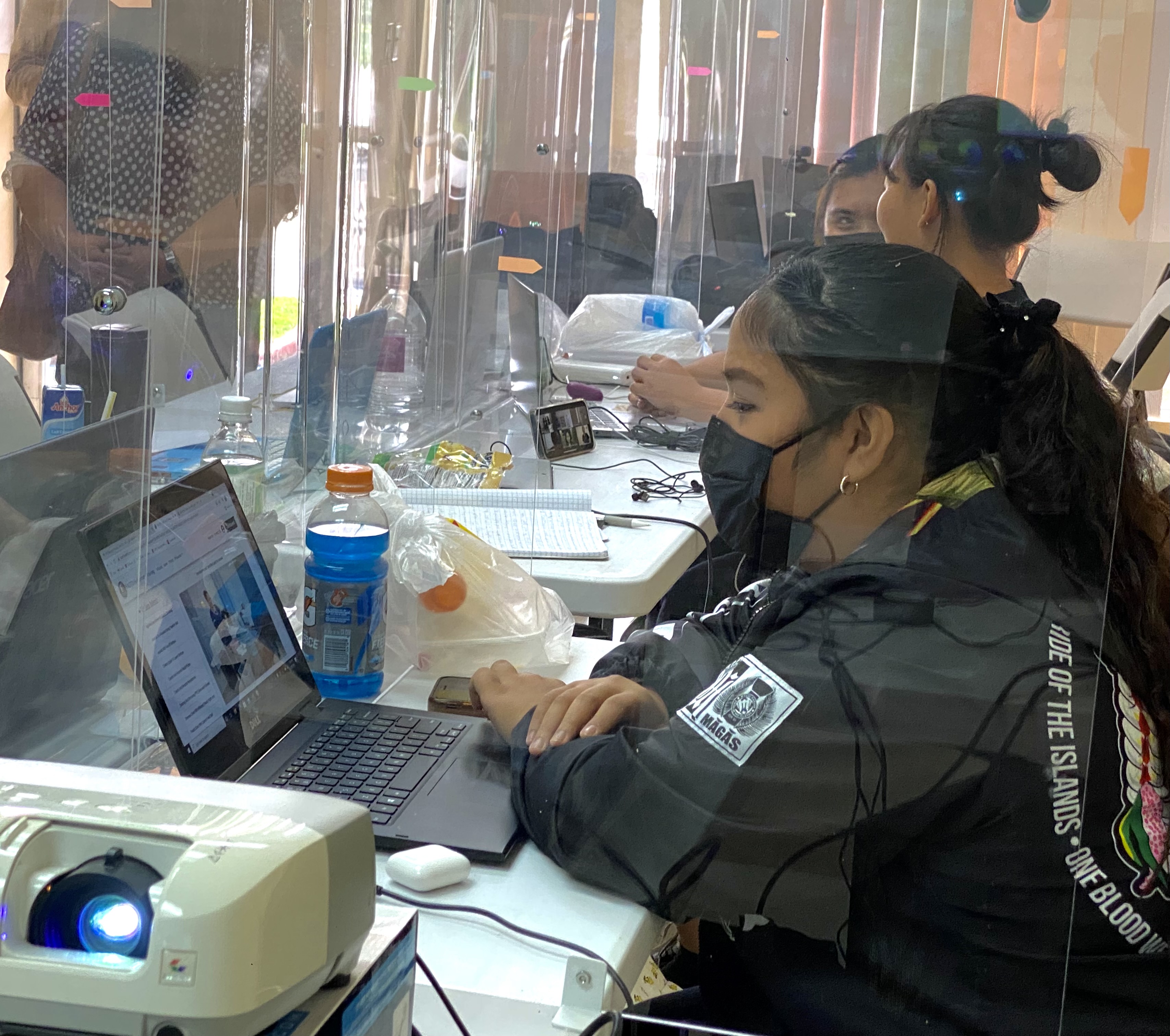 Students attend a synchronous online class in a socially distanced classroom.