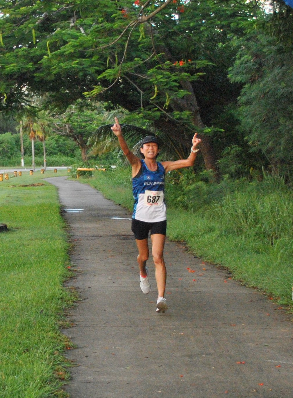 Noriko Jim celebrates as she crosses the finish line.