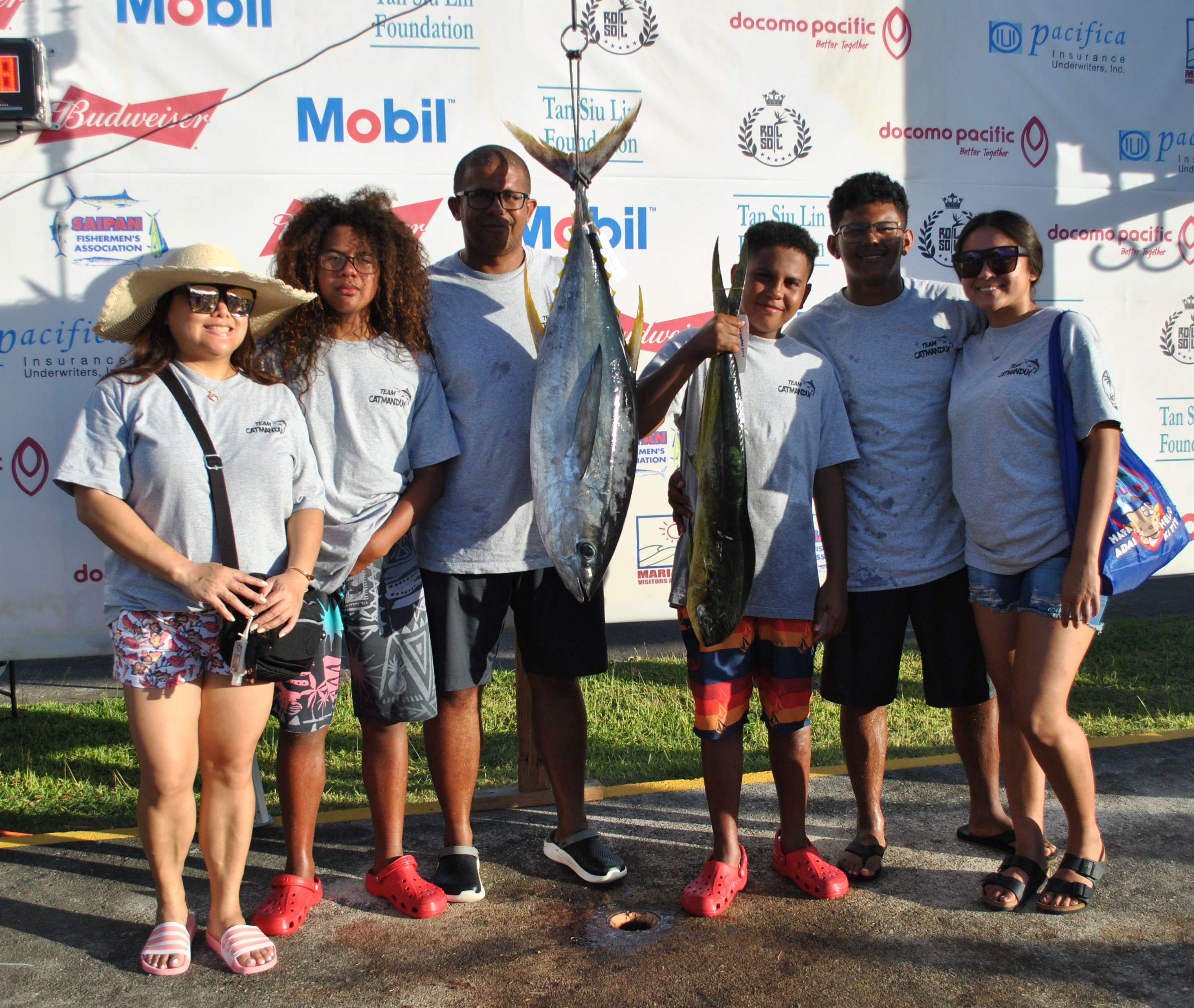 The crewmembers of Catmandu pose with the fish they caught.