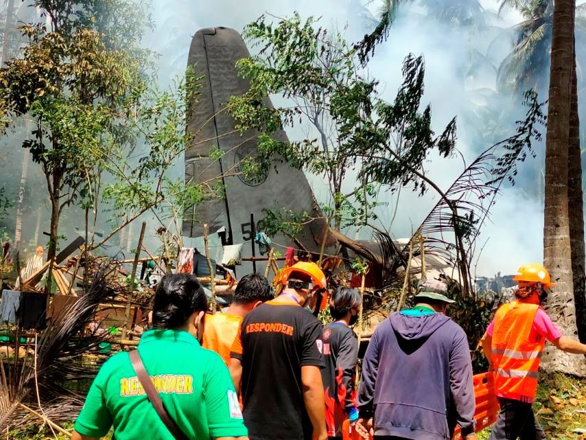 First responders work at the site after a Philippines Air Force Lockheed C-130 plane carrying troops crashed on landing in Patikul, Sulu province on July 4, 2021.