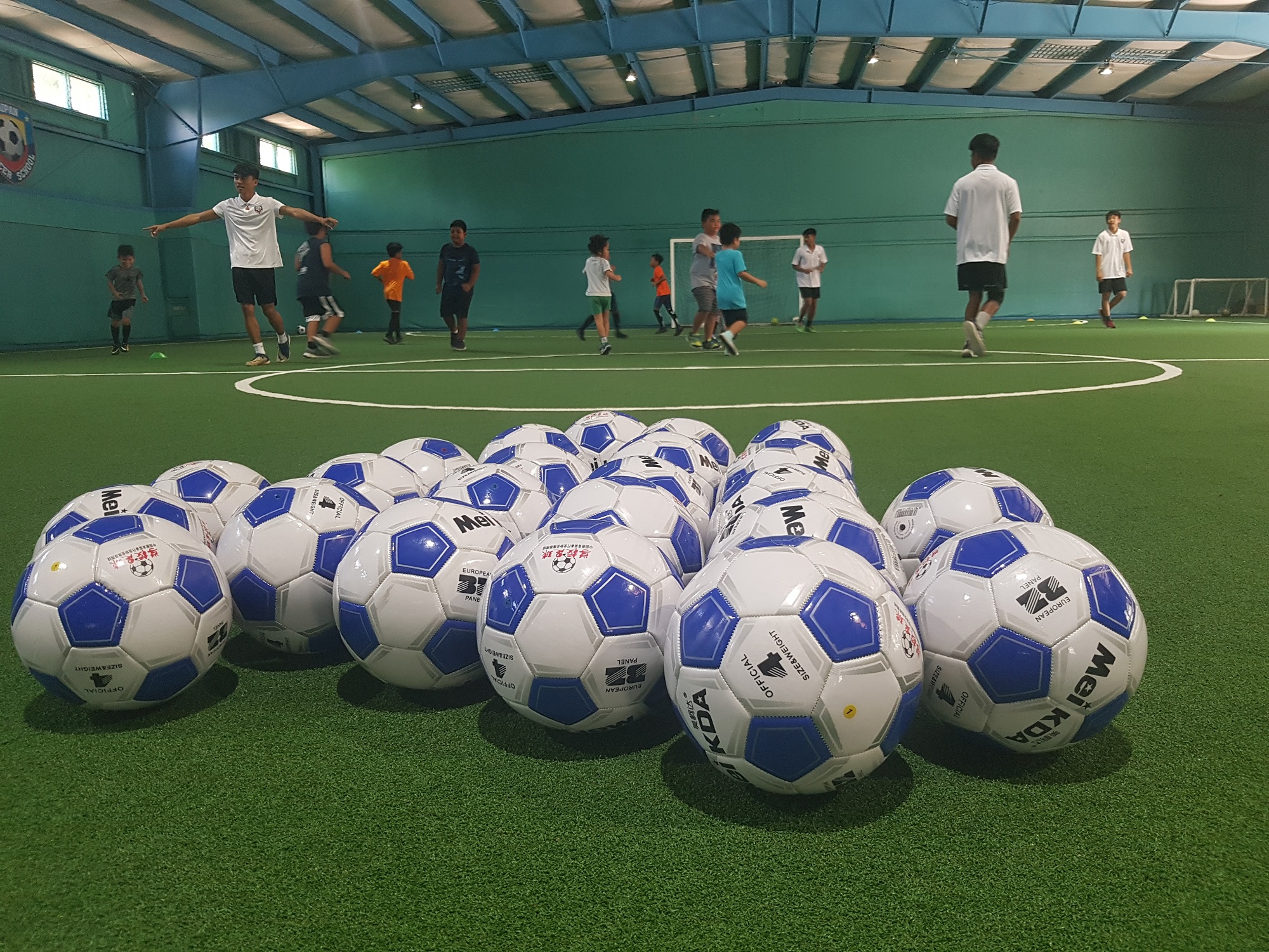 Camp participants and volunteers perform warm-up drills during their first futsal session.