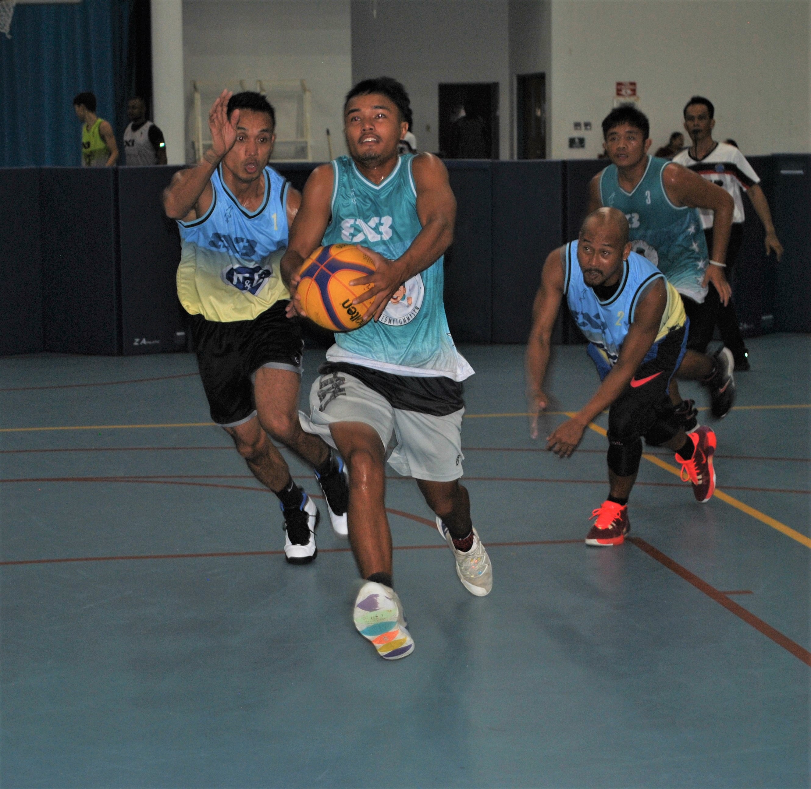A Tinian Typhoon gathers for the layup after passing two defenders.