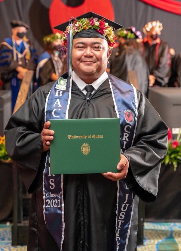 Daniel Kintol holds his University of Guam diploma at the Northern Marianas College commencement ceremony on May 21, 2021.