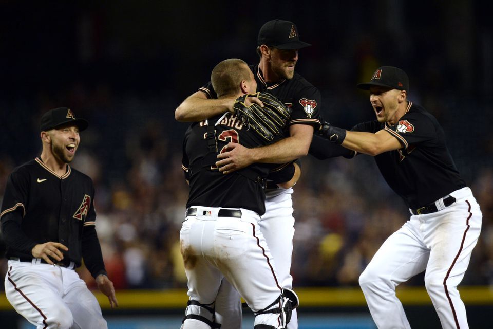 Arizona Diamondbacks starting pitcher Tyler Gilbert (49) celebrates with Arizona Diamondbacks third baseman Drew Ellis (27) and Arizona Diamondbacks catcher Daulton Varsho (12) and Arizona Diamondbacks shortstop Nick Ahmed (13) after throwing a no hitter against the San Diego Padres at Chase Field in Phoenix, Arizona on Aug. 14, 2021.