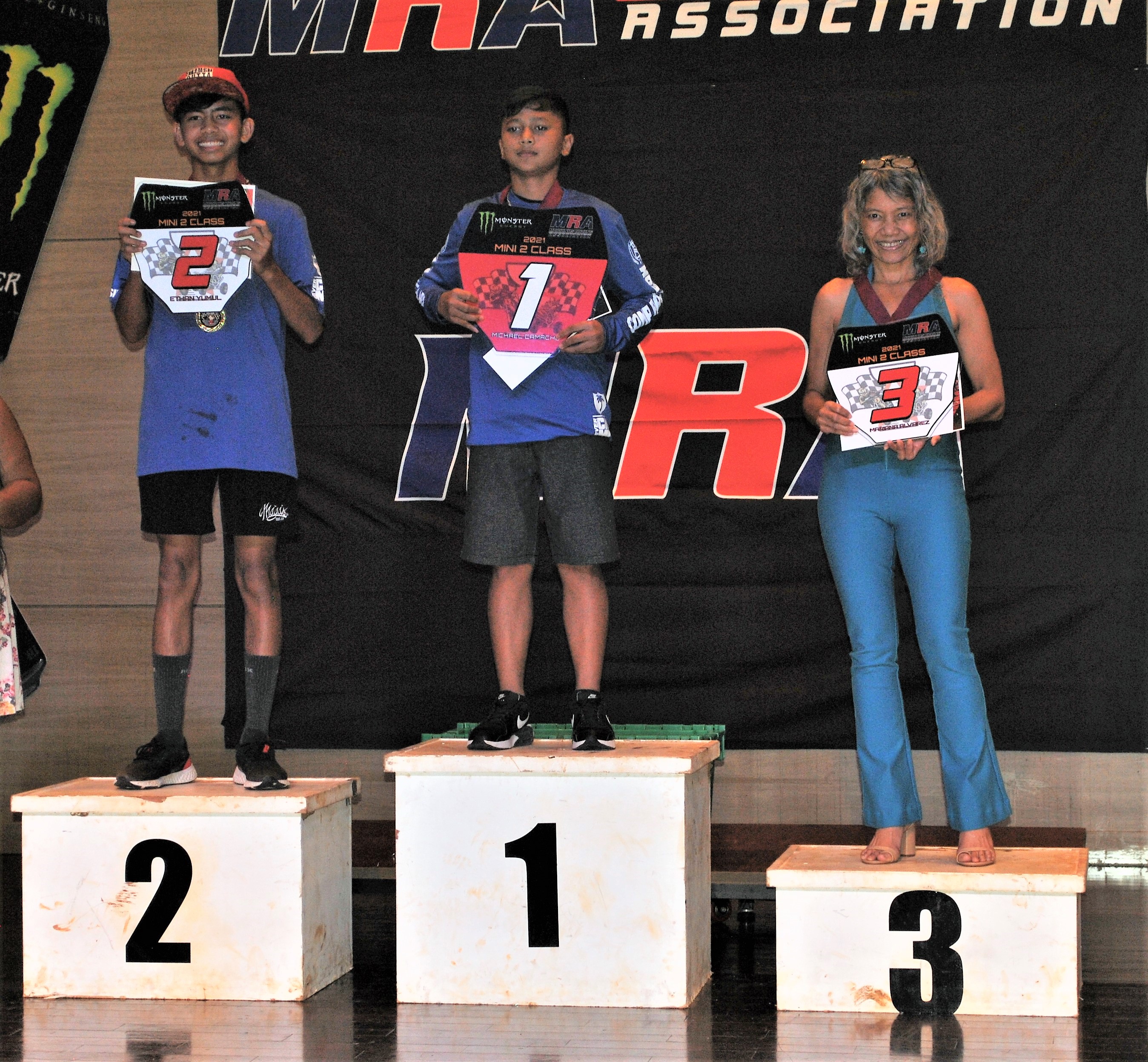 Michael Camacho Jr, center, holds the Red Plate first prize trophy in Mini 2 Class with Ethan Yumul, left, who finished second, and third place Mariana Alvarez, right, at the awards banquet of the Marianas Racing Association 2021 Points Race Series  on July 28 at the Saipan World Resort Taga Hall.