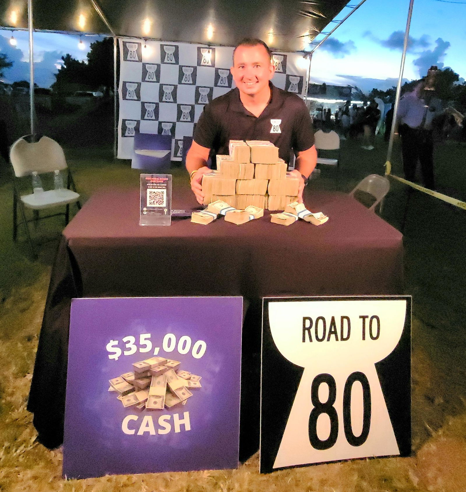 Campaign spokesperson Brad Ruszala poses for a photo with the displayed cash prize on Saturday during the Taste of the Marianas at the Garapan Fishing Base.