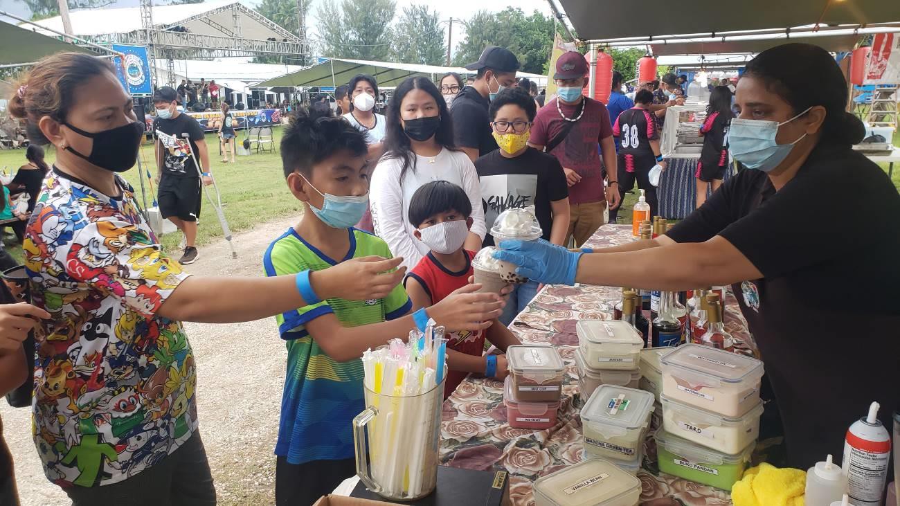 Manju  Pandy  of  Java  Joe’s,  right,  serves  festivalgoers  at  the  Marianas  Visitors Authority’s Hafa Adai & Tirow Summer Jam on July 31, 2021.