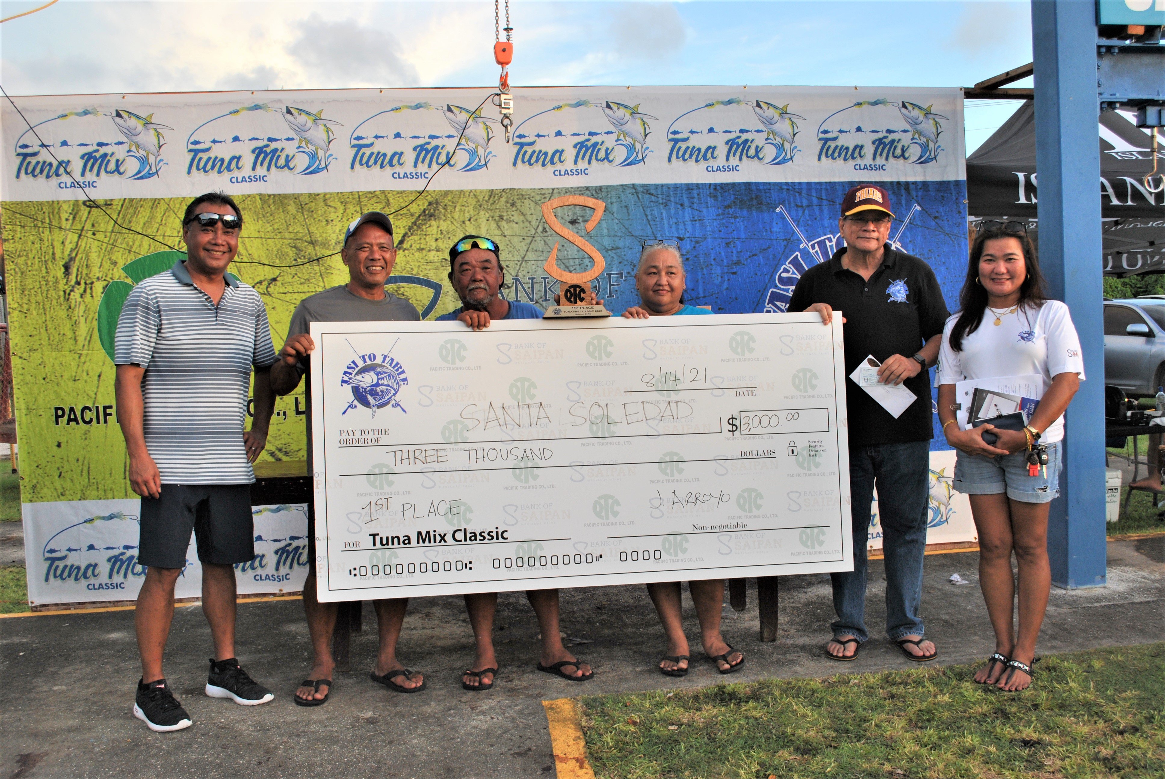 Santa Soledad crewmembers display their ceremonial check for $3,000 as they pose for a photo with  Tasi To Table vice president Wayne Pangelinan, president Gene Weaver, Bank of Saipan president John Arroyo and TTT's Normie Faura.