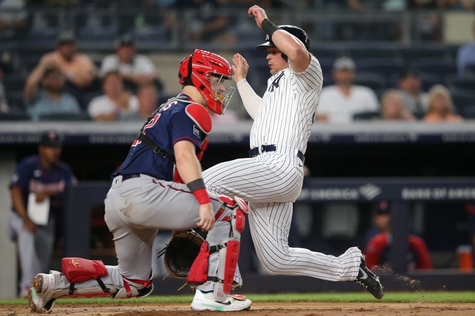 New York Yankees designated hitter Luke Voit (59) scores against Minnesota Twins catcher Ryan Jeffers (27) on a sacrifice fly by first baseman Anthony Rizzo (not pictured) during the third inning at Yankee Stadium in Bronx, New York on Aug 19, 2021.