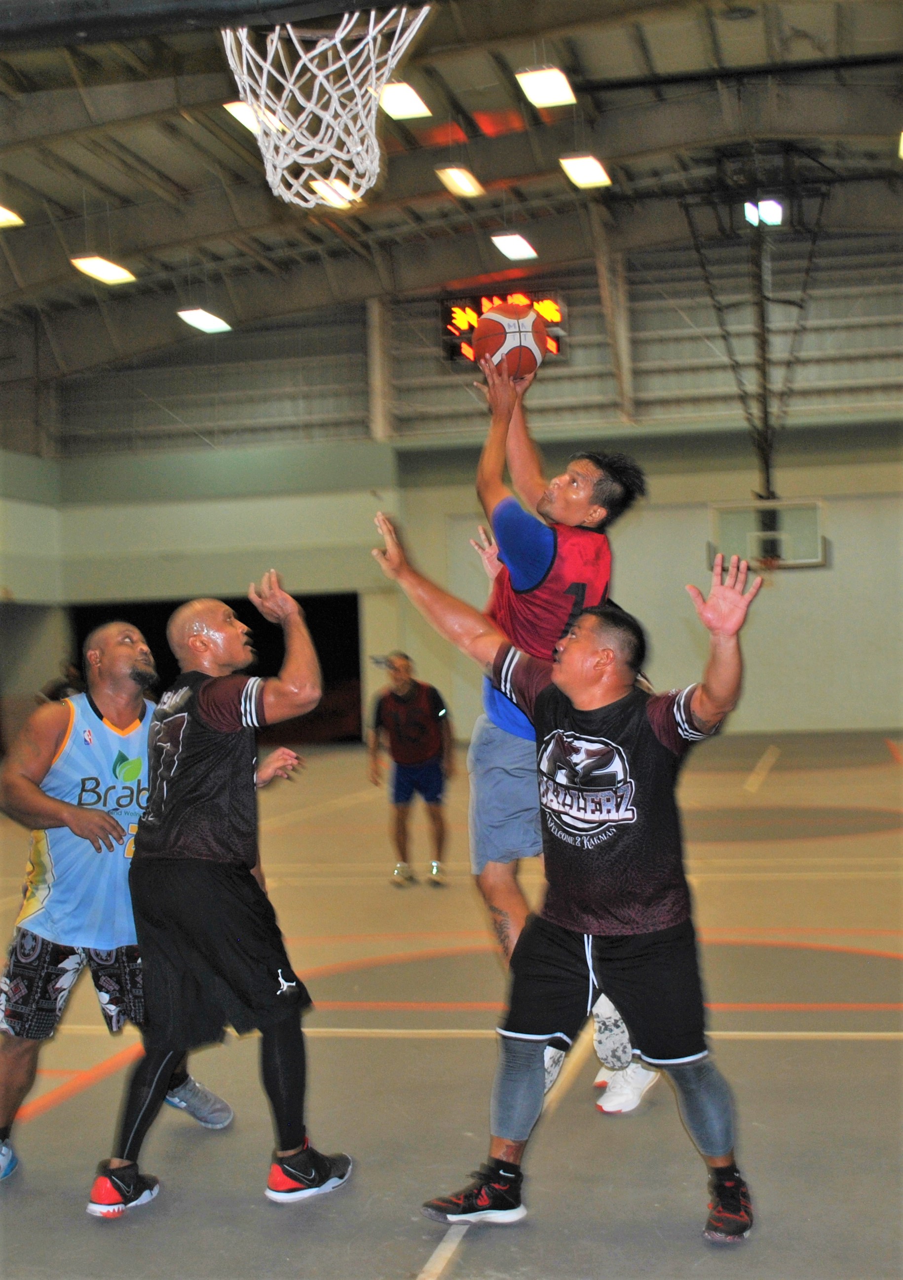 Gus Castro attempts a hook shot over K2 Ballers defenders during an NMI Rollers Basketball Association tournament game at  Koblerville gym on Saturday.