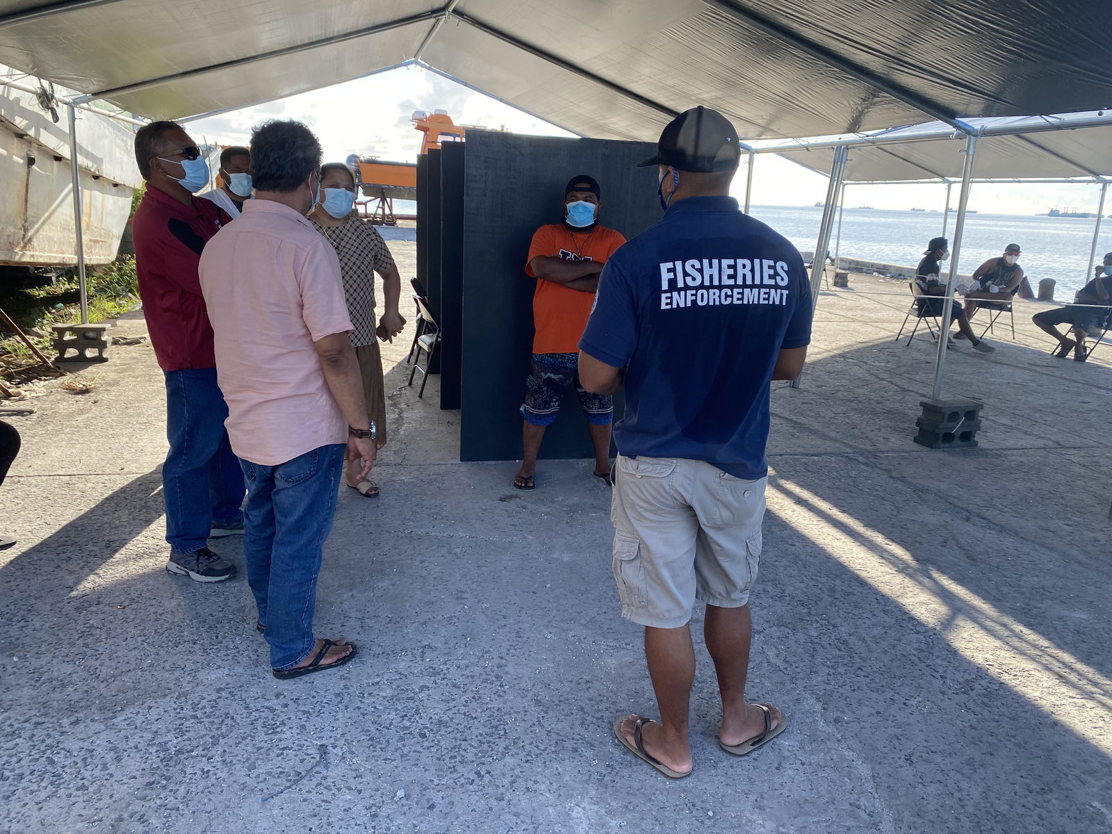 Fisheries, Ports and Ministry of Health officials confer at the dockside vaccination station Thursday on preparations for the resumption of Covid vaccinations for commercial tuna fishermen.