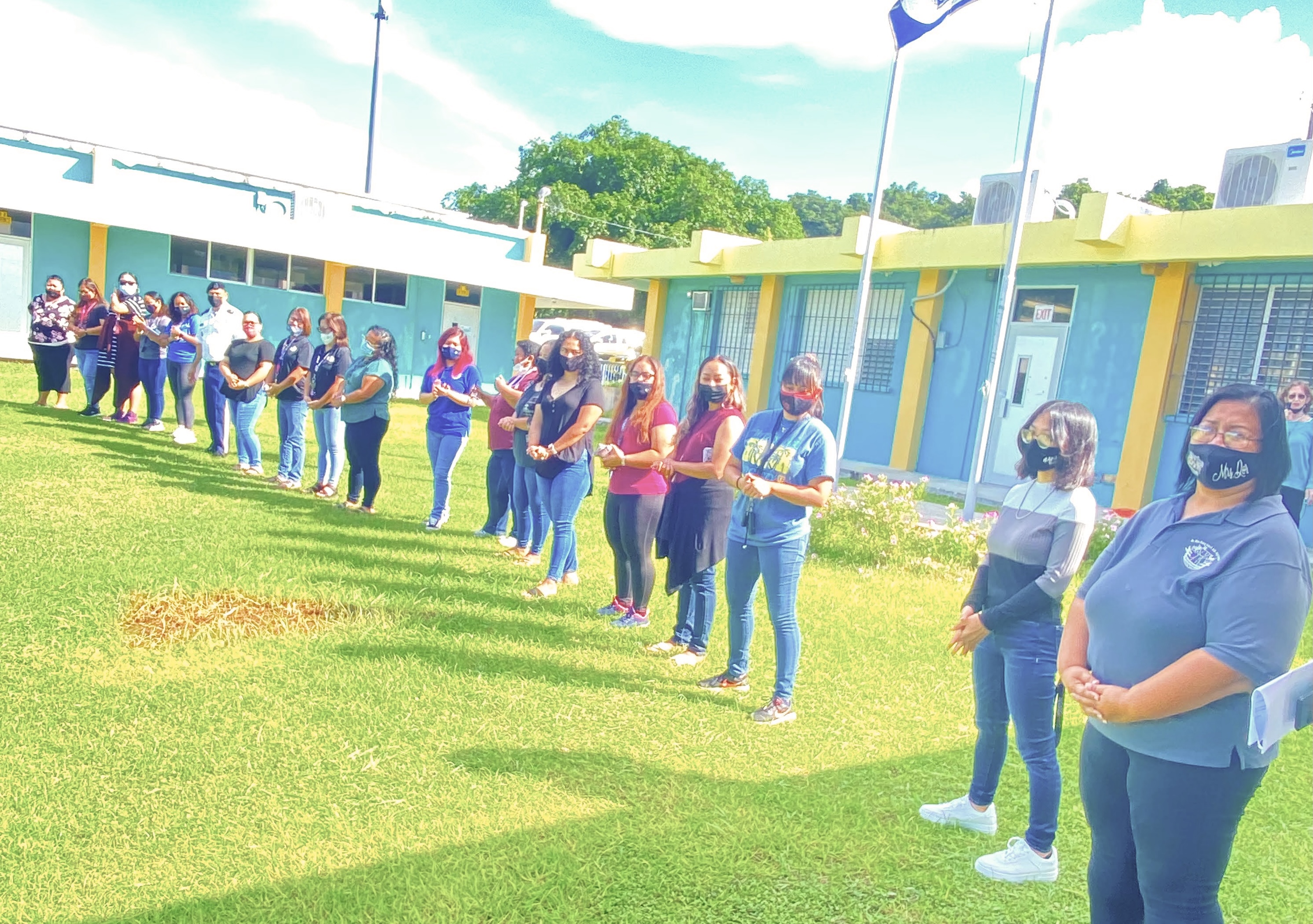 The staff of Dr. Rita H. Inos Junior-Senior High School on Rota take part in a  flag-raising ceremony on the first day of the new school year.
