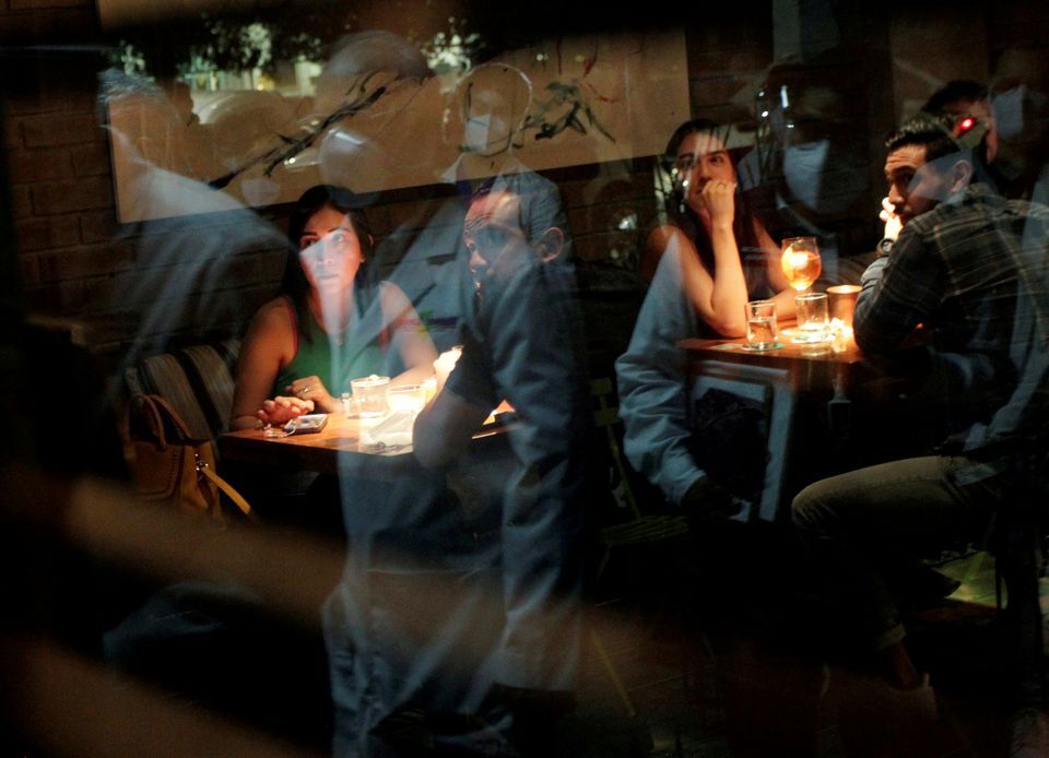 Medical workers are reflected on a window during a tour in nightclubs and restaurants to check that they do not exceed the allowed capacity, amid the coronavirus disease outbreak, in San Pedro Garza Garcia, on the outskirts of Monterrey, Mexico on July 24, 2021.