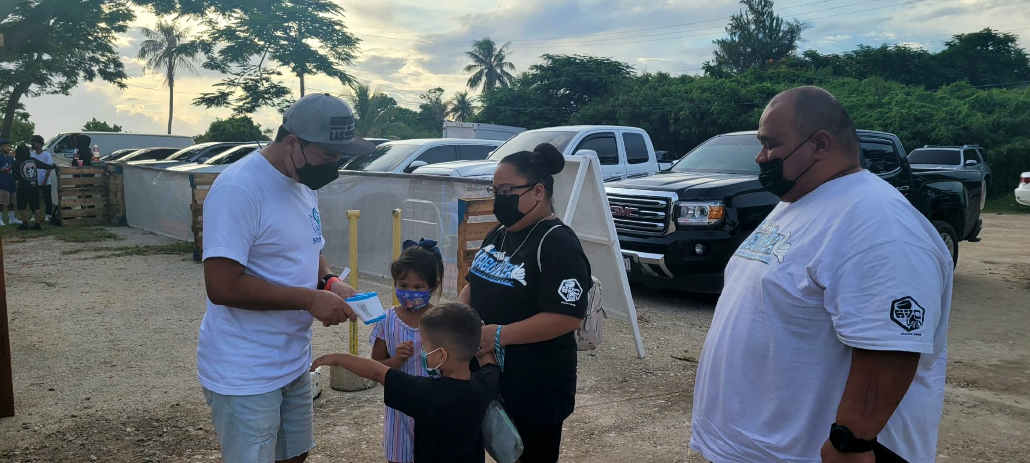 A family undergoes a temperature check before entering the festival grounds on Friday.