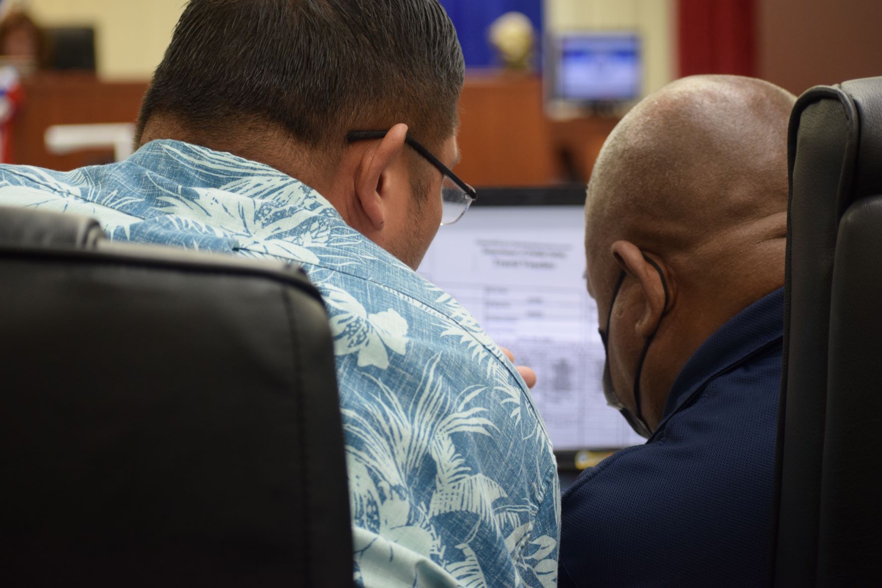 Department of Public Safety-Boating Safety Lt. Emery Kaipat, right, listens to his legal counsel, Anthony Aguon, during a hearing in the House chamber on Friday.