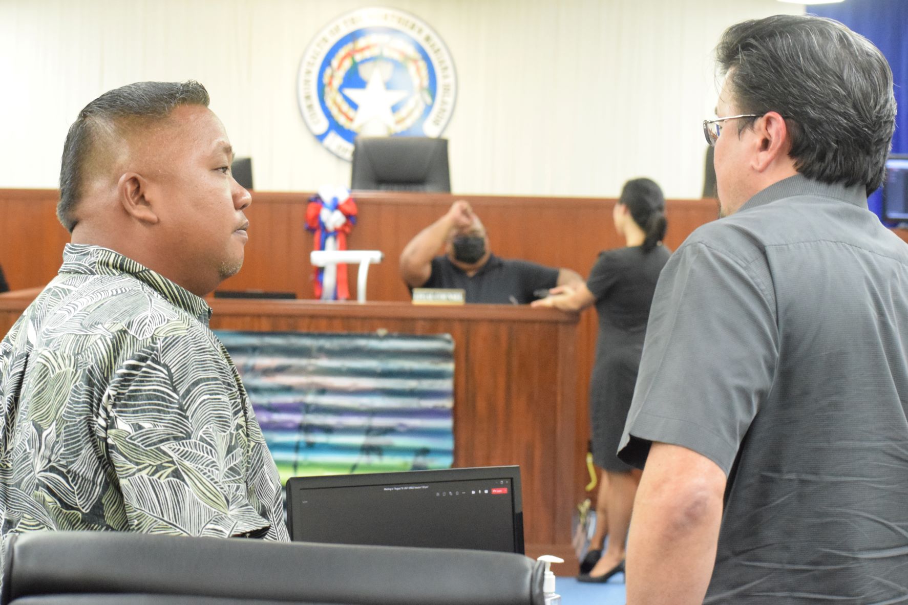 Reps. Angel Demapan and Edwin Propst confer during a break from the delegation session on Tuesday.