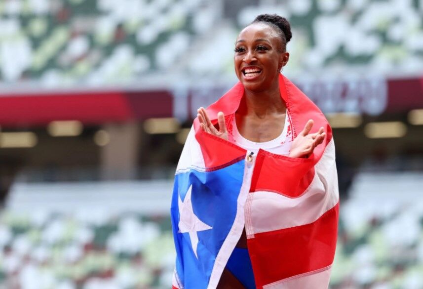 Jasmine Camacho-Quinn of Puerto Rico celebrates with her national flag after winning gold in the women's 100m hurdles final at the Olympic Stadiumi in Tokyo, Japan on Aug. 2, 2021.